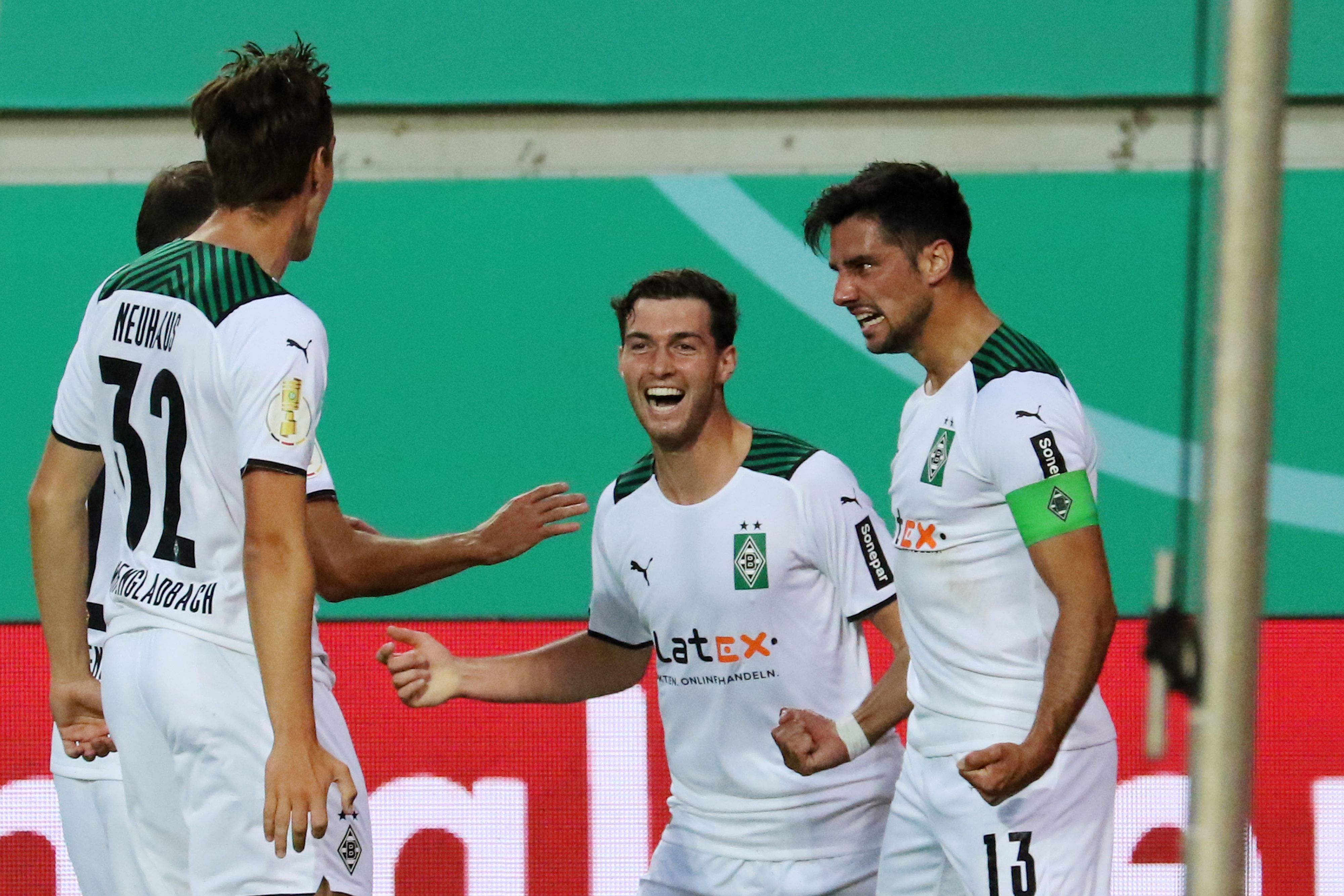 Die Gladbacher Florian Neuhaus und Joe Scally  bejubeln gemeinsam mit Torschütze Lars Stindl das 1:0 in der 1. Runde des DFB-Pokals beim 1. FC Kaiserslautern am 9. August 2021.