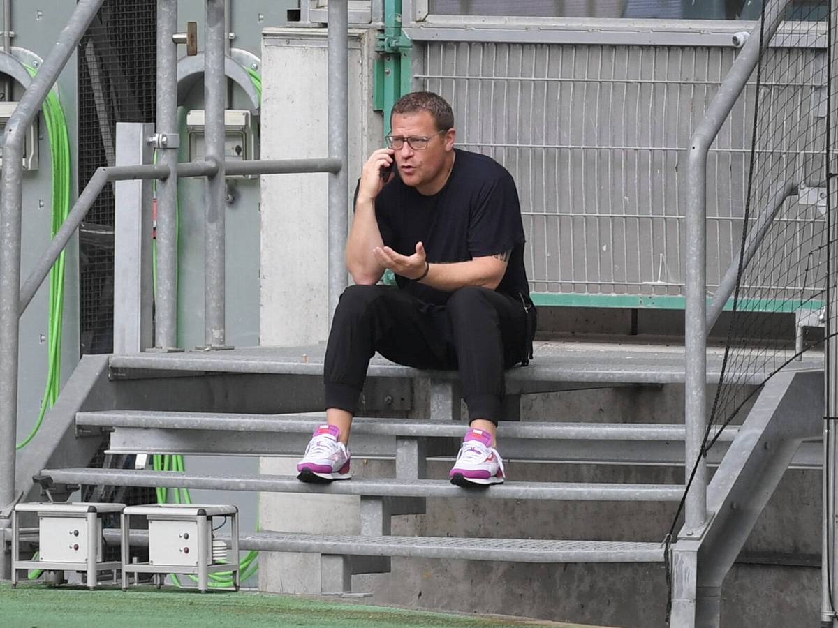 Gladbach-Manager Max Eberl sitzt auf einer Metalltreppe im Borussia-Park, derweil telefoniert er mit seinem Smartphone, mit der linken Hand gestikuliert er.
