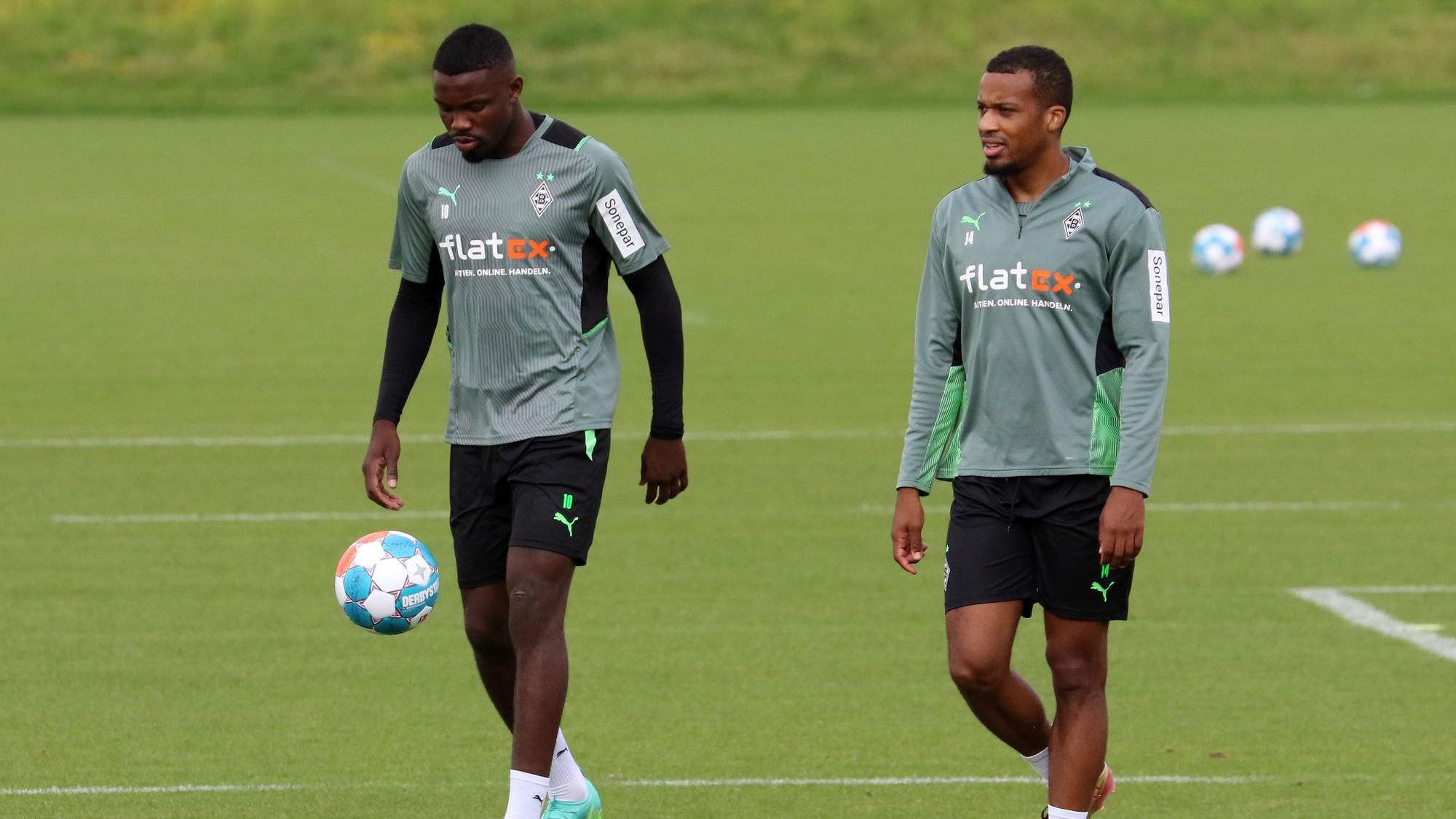 Die beiden Gladbach-Stürmer Marcus Thuram (l.) und Alassane Plea (r.) gehen am Mittwoch (11. August 2021) über das Trainingsgelände im Borussia-Park.