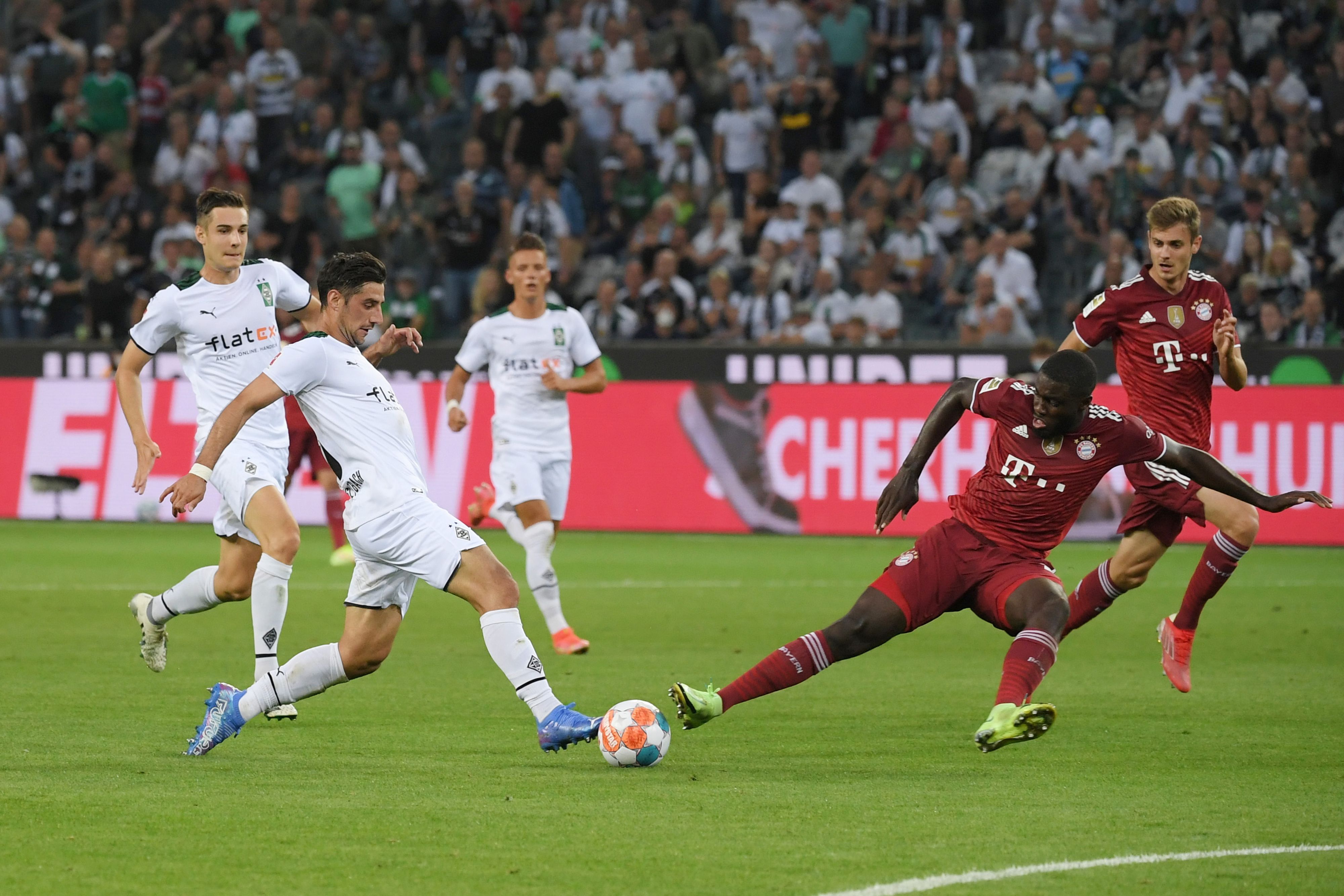Gladbachs Lars Stindl (l.) beim Bundesliga-Eröffnungsspiel am 13. August 2021 im Zweikampf mit Bayerns Dayot Upamecano (r.).