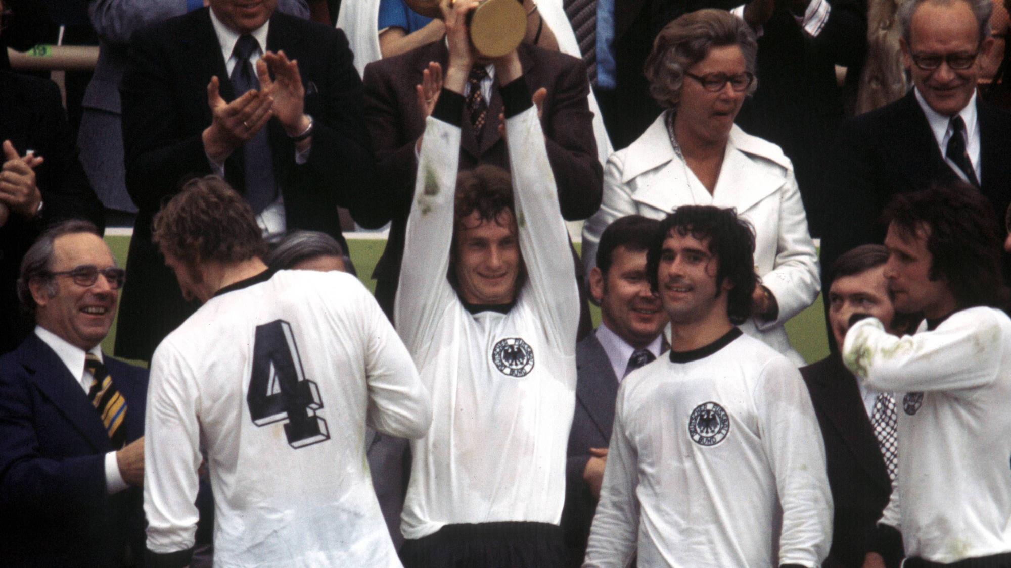 WM 1974, Siegerehrung Weltmeister BR Deutschland - Rainer Bonhof präsentiert den Pokal, daneben Hans Georg -Katsche- Schwarzenbeck, Gerd Müller und Wolfgang Overath
World Cup 1974 Award Ceremony World Champion BR Germany Rainer Bonhof presents the Cup next to it Hans Georg Katsche Schwarzenbeck Gerd Mueller and Wolfgang Overath
