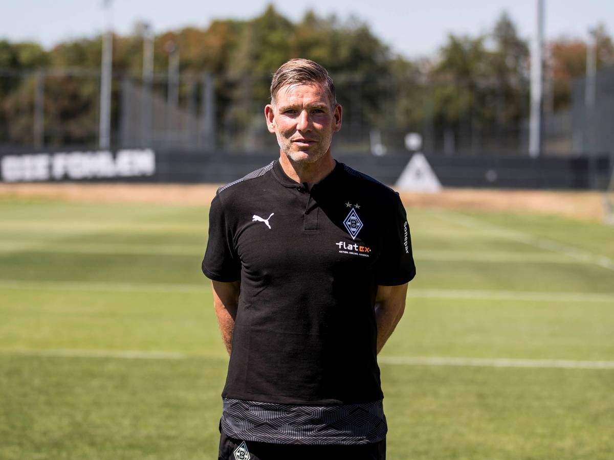 Gladbach-Legende und Torwarttrainer Uwe Kamps blickt in die Kamera, seine Arme hat er auf dem Rücken verschränkt.