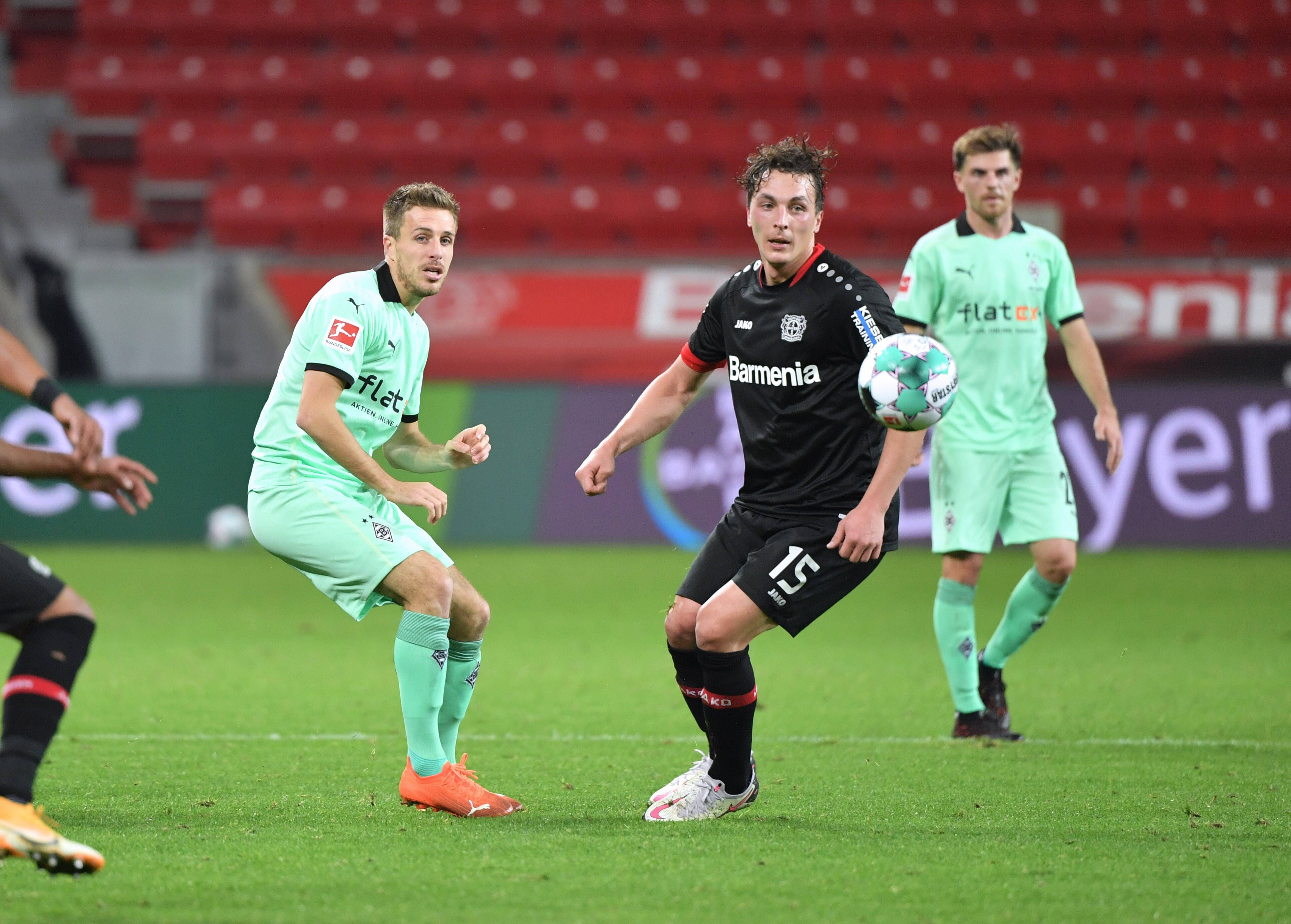 Gladbachs Patrick Herrmann ( und Leverkusens Julian Baumgartlinger am 08.November 2020 beim Bundesliga-Duell der beiden Klubs. Beide schauen dem Ball hinterher.