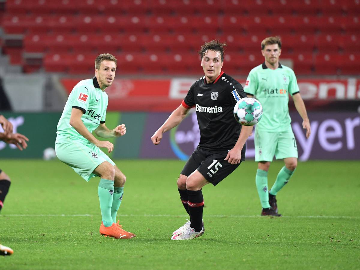 Gladbachs Patrick Herrmann ( und Leverkusens Julian Baumgartlinger am 08.November 2020 beim Bundesliga-Duell der beiden Klubs. Beide schauen dem Ball hinterher.