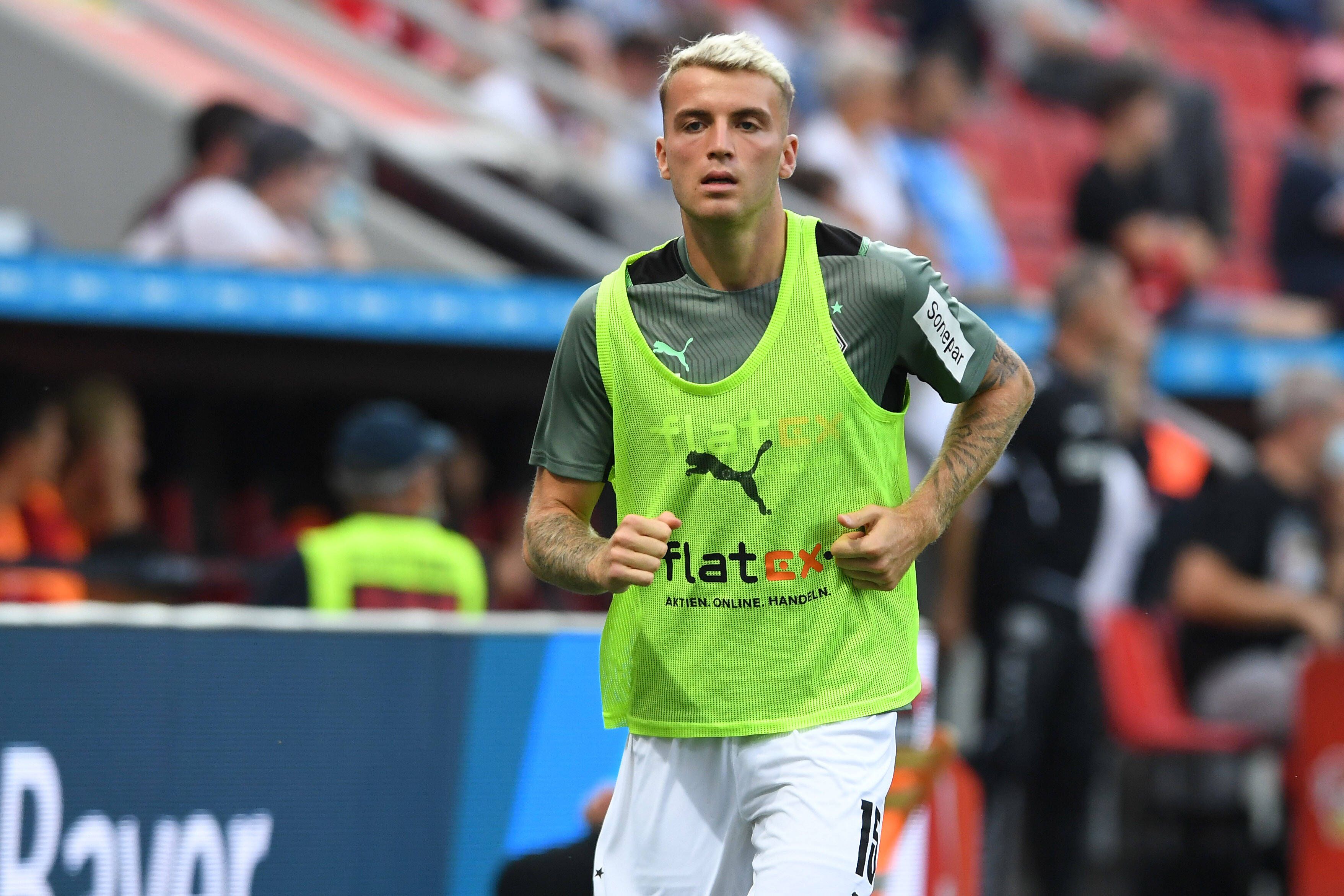 Gladbach-Verteidiger Jordan Beyer, hier zu sehen am 21. August 2021 bei Borussias Niederlage (0:4) in Leverkusen. Beyer läuft sich an der Seitenlinie warm, er trägt ein gelbes Leibchen.