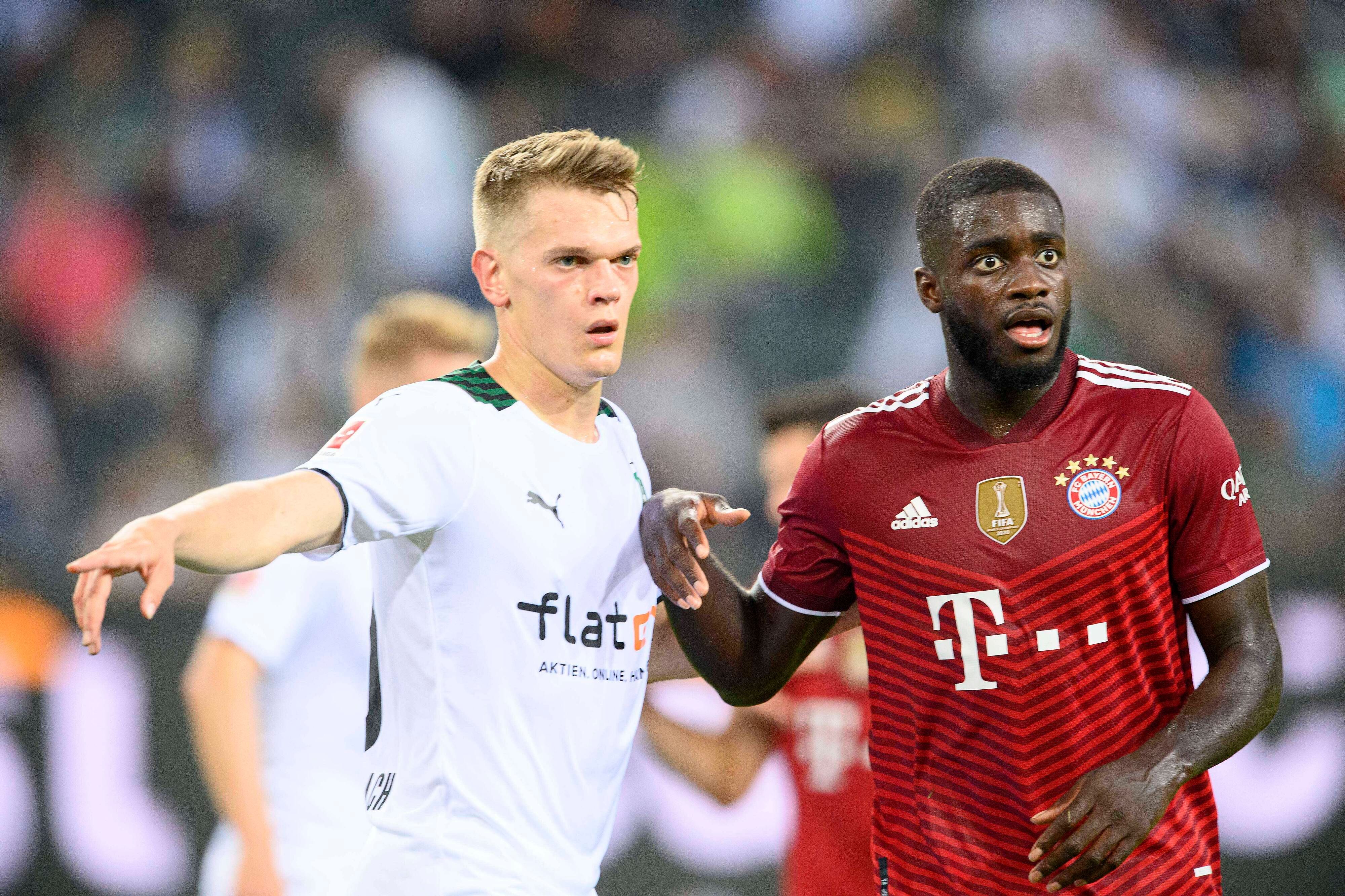 Gladbachs Nationalspieler Matthias Ginter (l.) im Duell mit Bayern-München-Verteidiger Dayot Upamecano (r.) beim Bundesliga-Spiel am 13. August 2021. Beide Spieler blicken auf den Ball.