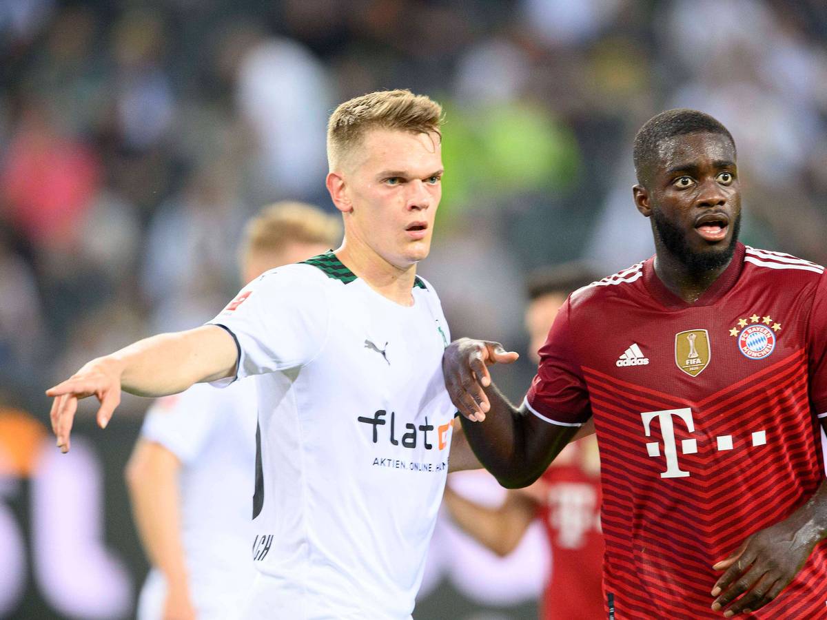 Gladbachs Nationalspieler Matthias Ginter (l.) im Duell mit Bayern-München-Verteidiger Dayot Upamecano (r.) beim Bundesliga-Spiel am 13. August 2021. Beide Spieler blicken auf den Ball.
