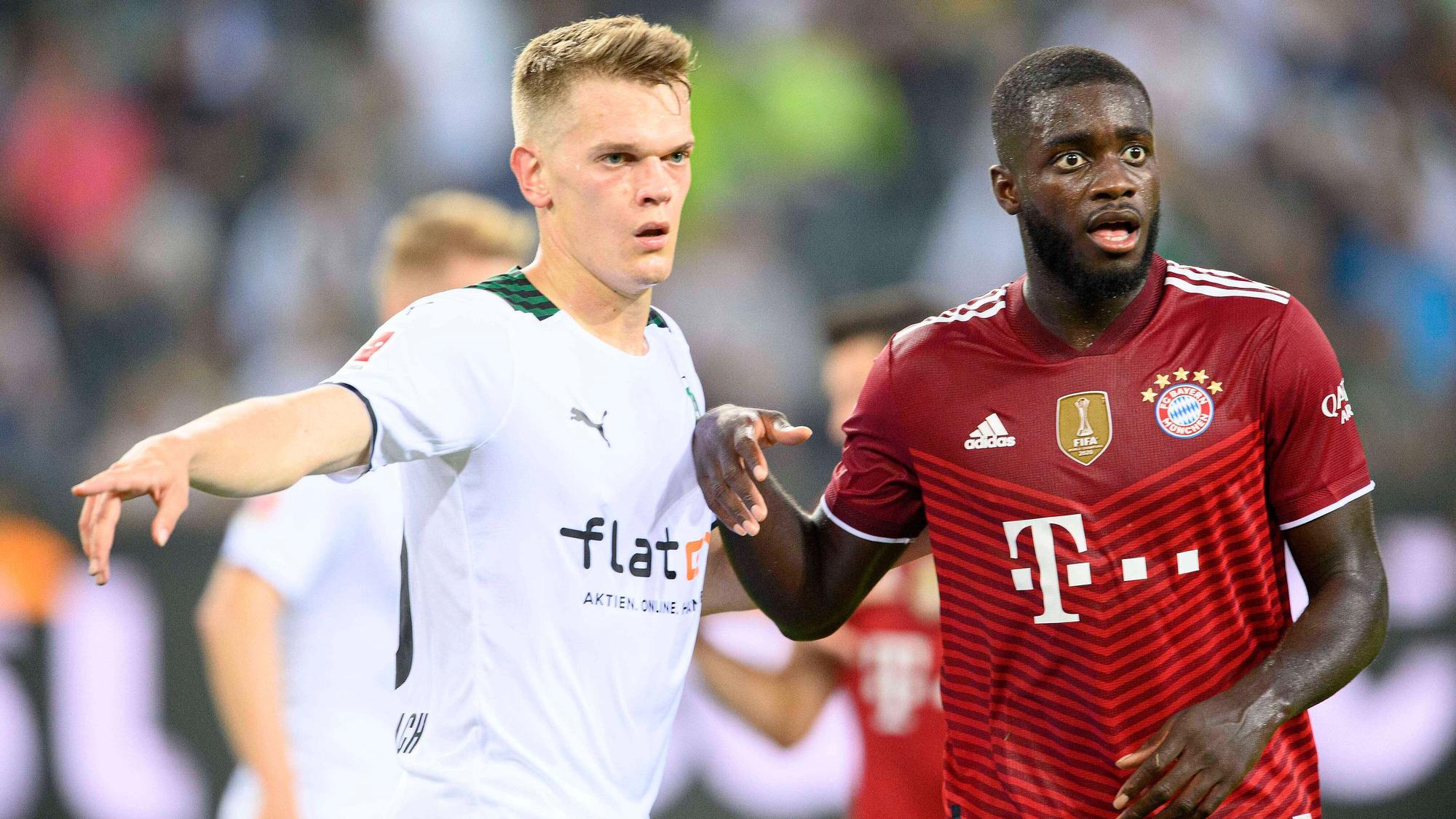 Gladbachs Nationalspieler Matthias Ginter (l.) im Duell mit Bayern-München-Verteidiger Dayot Upamecano (r.) beim Bundesliga-Spiel am 13. August 2021. Beide Spieler blicken auf den Ball.