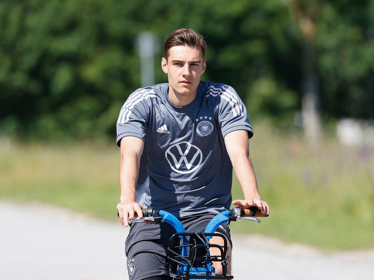 Gladbachs Nationalspieler Florian Neuhaus, hier zu sehen bei einer Radtour während des DFB-Trainingslagers in Herzogenaurach am 17. Juni 2021. Neuhaus sitzt auf einem Rand und schaut in die Kamera.