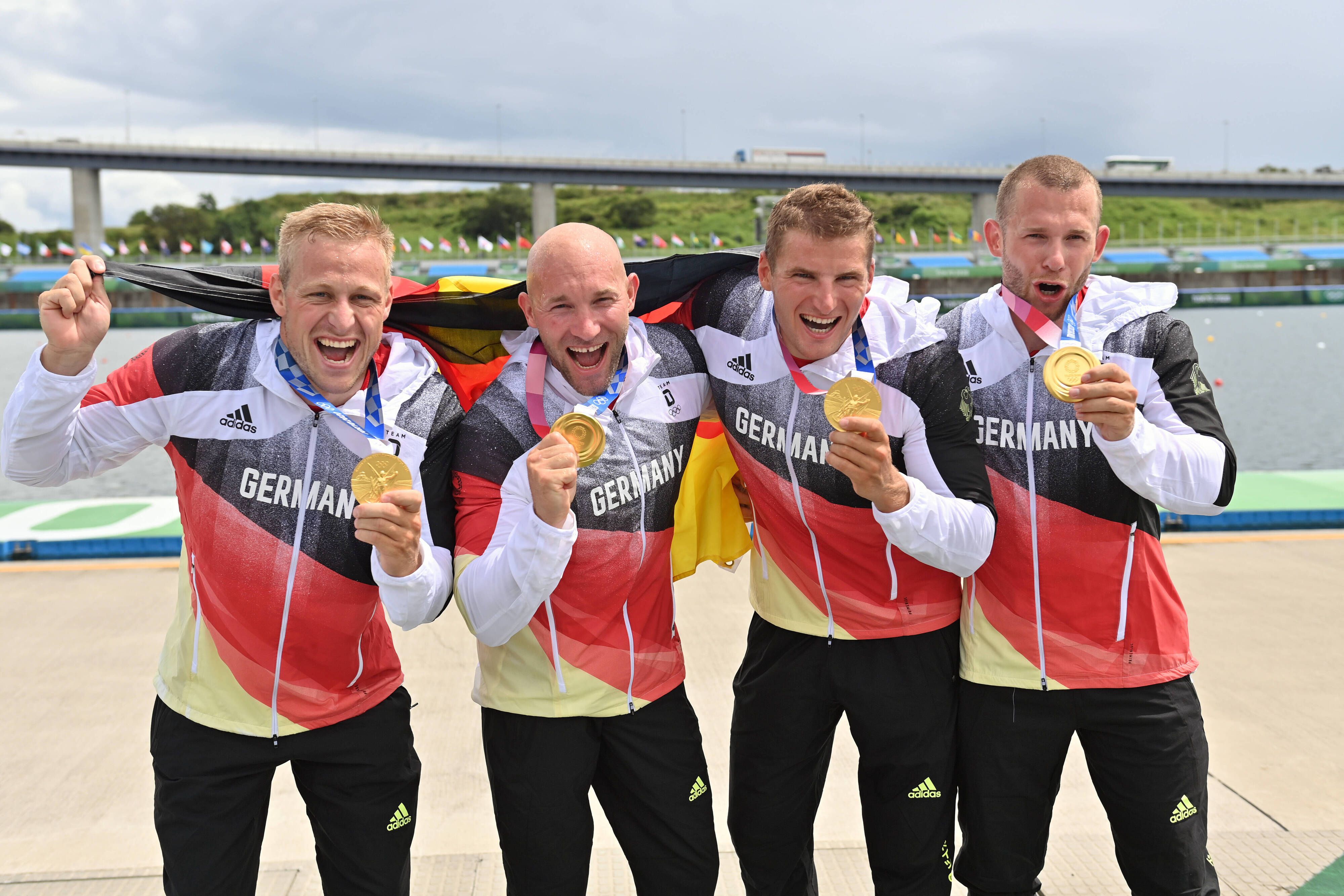 Die Kanu-Olympiasieger Max Rendschmidt, Ronald Rauhe, Tom Liebscher und Max Lemke (v. l. n. r.) feiern ihren Goldmedaillen-Gewinn im 500-Meter-Sprint am 7. August 2021. Rauhe lost am Sonntag (29. August) die 2. Runde im DFB-Pokal aus.