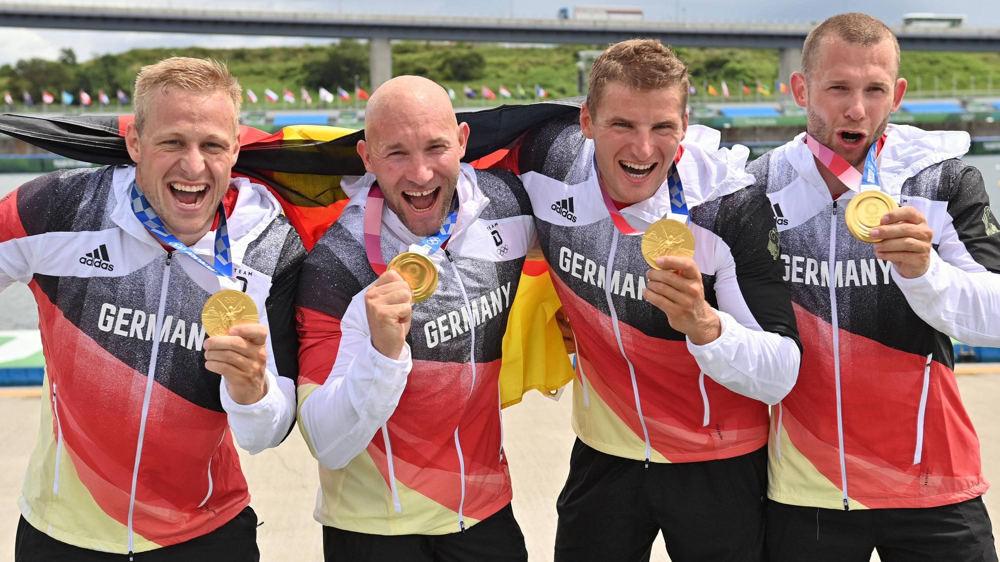 Die Kanu-Olympiasieger Max Rendschmidt, Ronald Rauhe, Tom Liebscher und Max Lemke (v. l. n. r.) feiern ihren Goldmedaillen-Gewinn im 500-Meter-Sprint am 7. August 2021. Rauhe lost am Sonntag (29. August) die 2. Runde im DFB-Pokal aus.