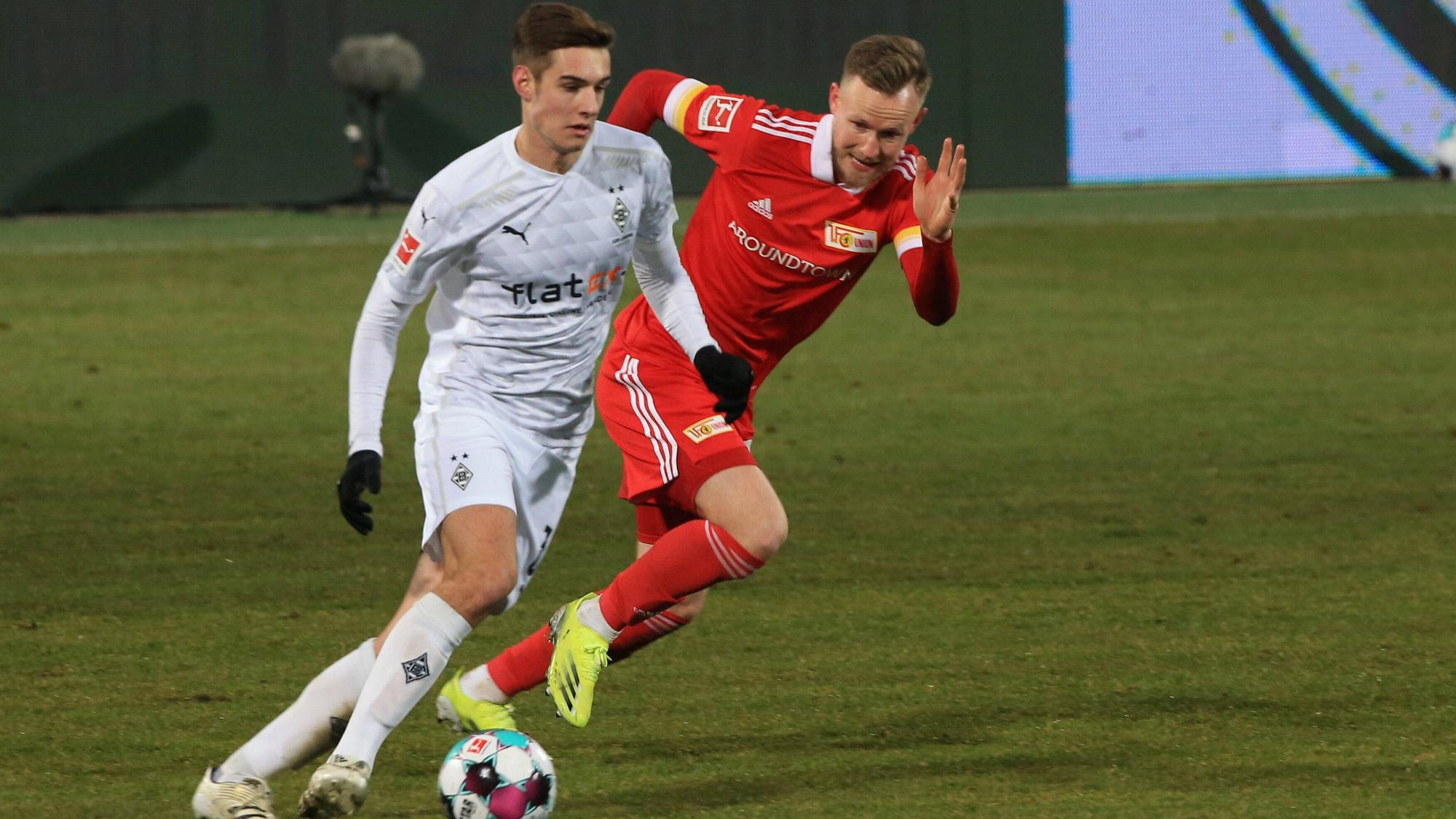 Florian Neuhaus (l.), Mittelfeldspieler von Borussia Mönchengladbach, am 30. Januar 2021 beim 1:1 im Bundesliga-Duell bei Union Berlin. Neuhaus kontrolliert mit dem rechten Fuß den Ball.