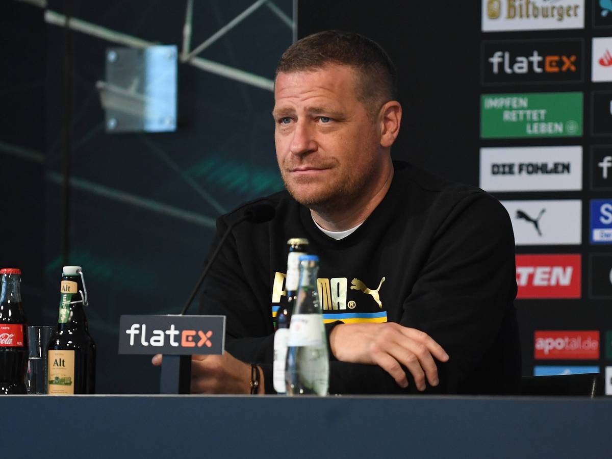 Gladbachs Sportdirektor Max Eberl lächelt mild auf der Pressekonferenz vor dem Auswärtsspiel zwischen Borussia Mönchengladbach und Union Berlin am 27. August 2021 im Borussia-Park am Podest sitzend.