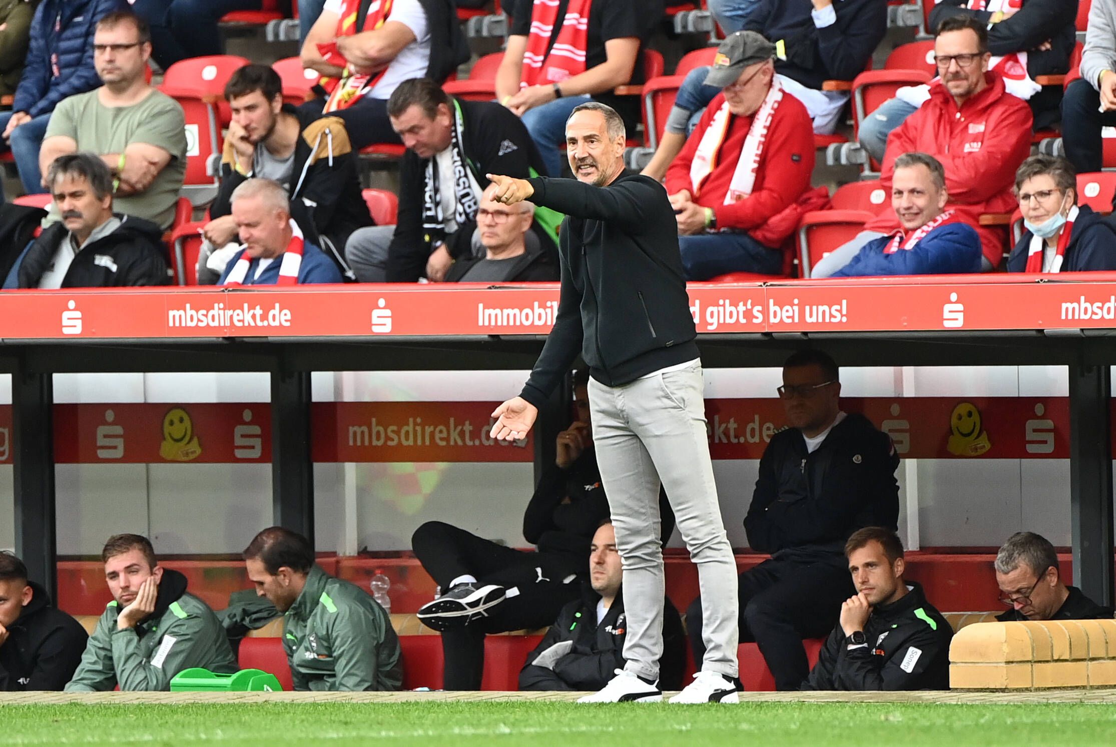 Adi Hütter, im Spiel der Gladbacher bei Union Berlin am 29. August 2021, hat den Arm ausgestreckt und deutet mit seinem Zeigefinger auf das Fußballfeld.