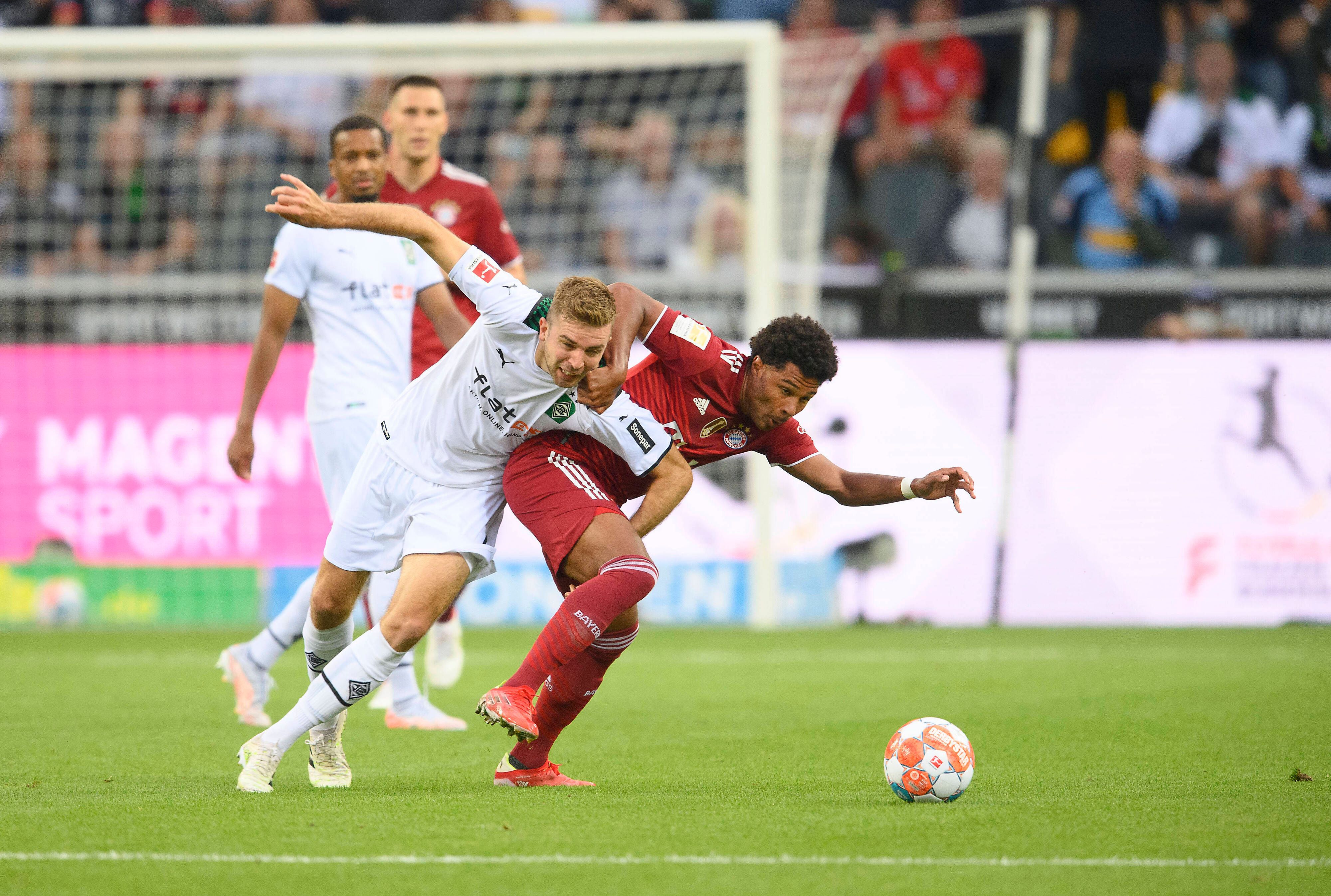 Gladbach-Profi Christoph Kramer (l.) im Zweikampf mit Bayern-München-Spieler Serge Gnabry (r.) beim Bundesliga-Duell am 13. August 2021 im Borussia-Park. Kramer und Gnabry ringen um den Ball.