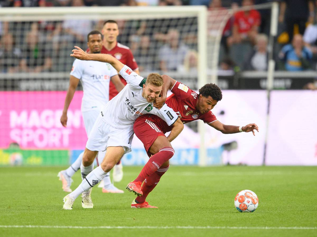 Gladbach-Profi Christoph Kramer (l.) im Zweikampf mit Bayern-München-Spieler Serge Gnabry (r.) beim Bundesliga-Duell am 13. August 2021 im Borussia-Park. Kramer und Gnabry ringen um den Ball.