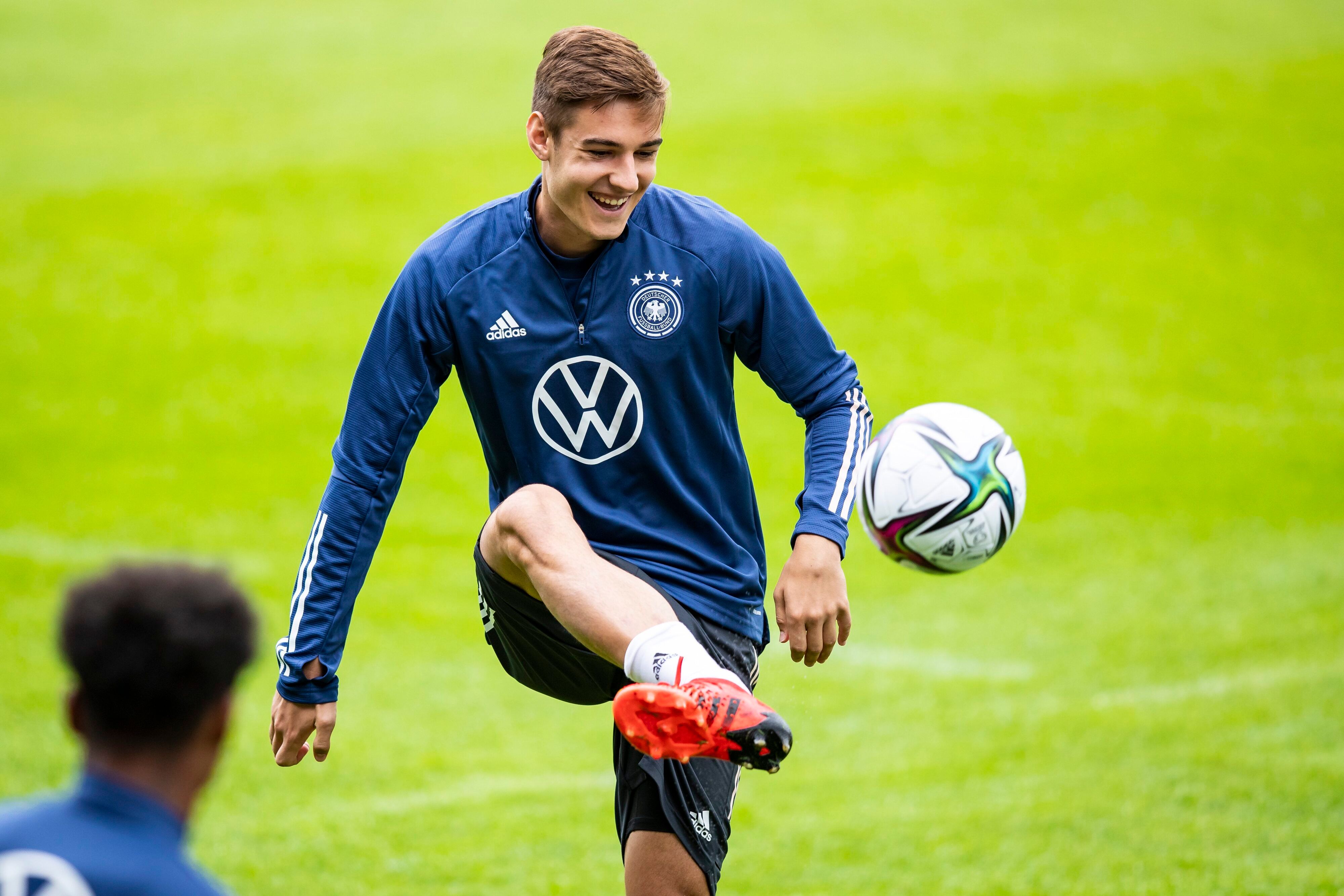 Gladbachs Florian Neuhaus jongliert bei einer Trainingseinheit der deutschen Nationalmannschaft am 31.08.2021in Stuttgart den Ball mit dem Fuß und lacht.