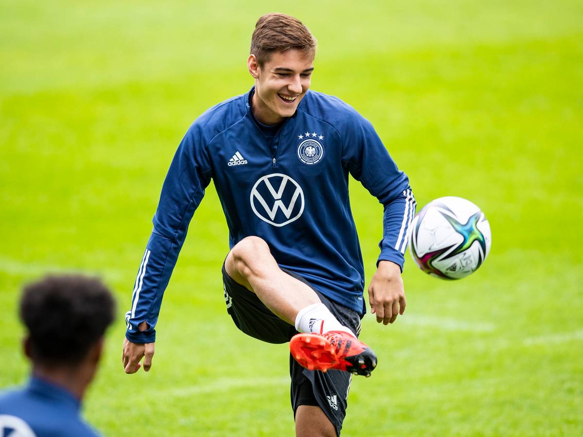Gladbachs Florian Neuhaus jongliert bei einer Trainingseinheit der deutschen Nationalmannschaft am 31.08.2021in Stuttgart den Ball mit dem Fuß und lacht.