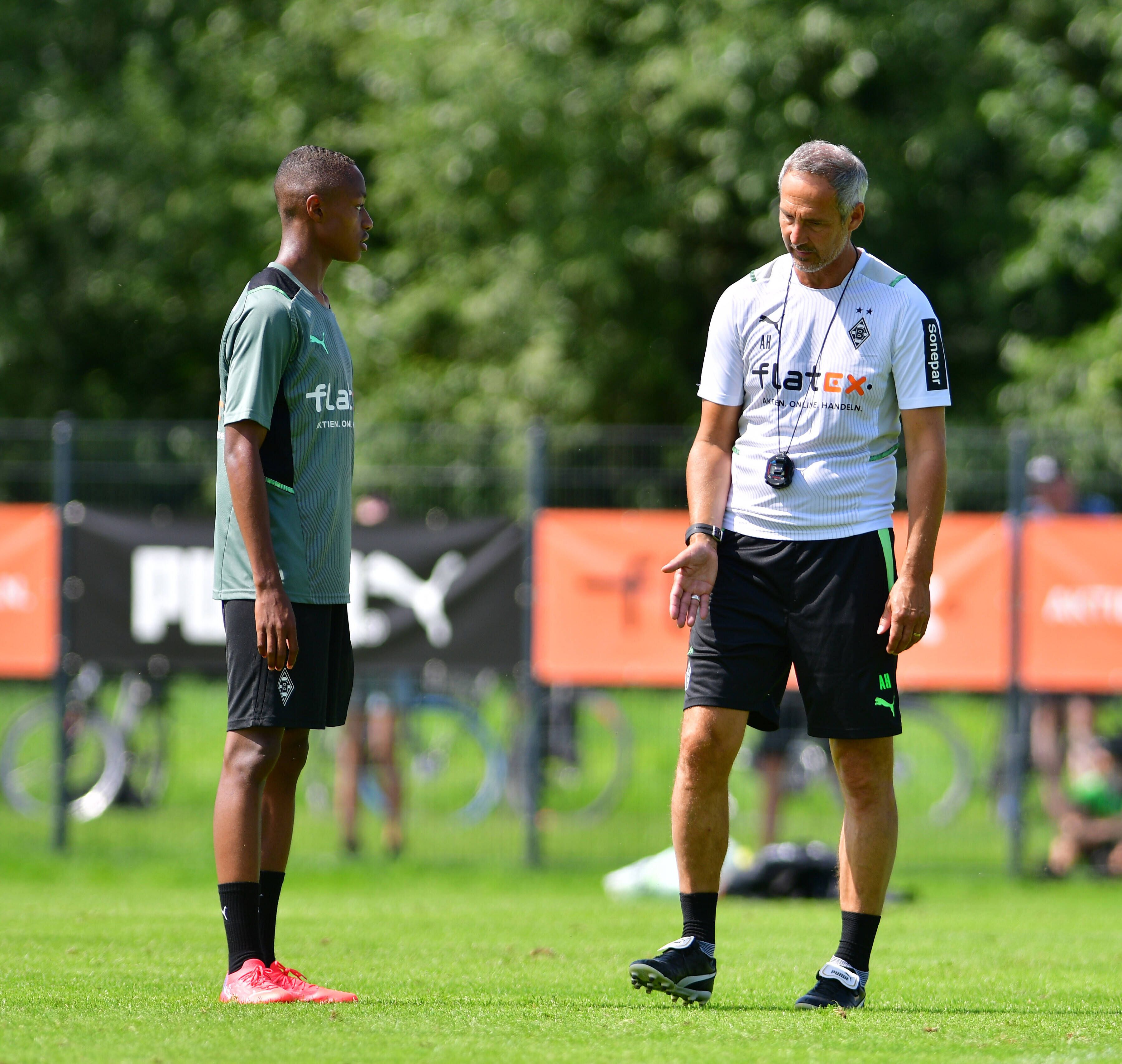 Gladbach-Cheftrainer Adi Hütter (r.) am 18. Juli 2021 in Harsewinkel im Gespräch mit Borussias neuem Nationalspieler Yvandro Borges Sanches (l.).