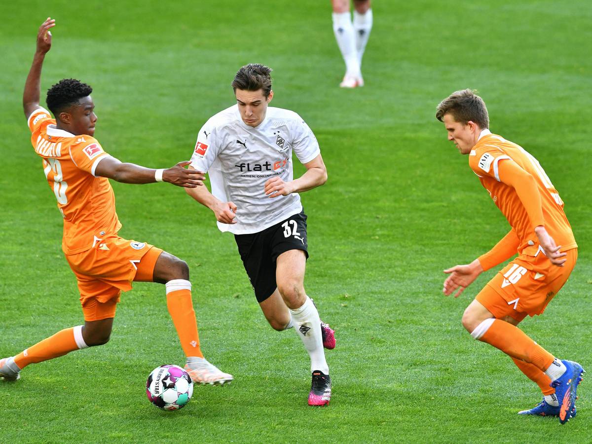 Florian Neuhaus von Borussia Mönchengladbach (Mitte) behauptet den Ball gegen zwei Gegenspieler von Arminia Bielefeld