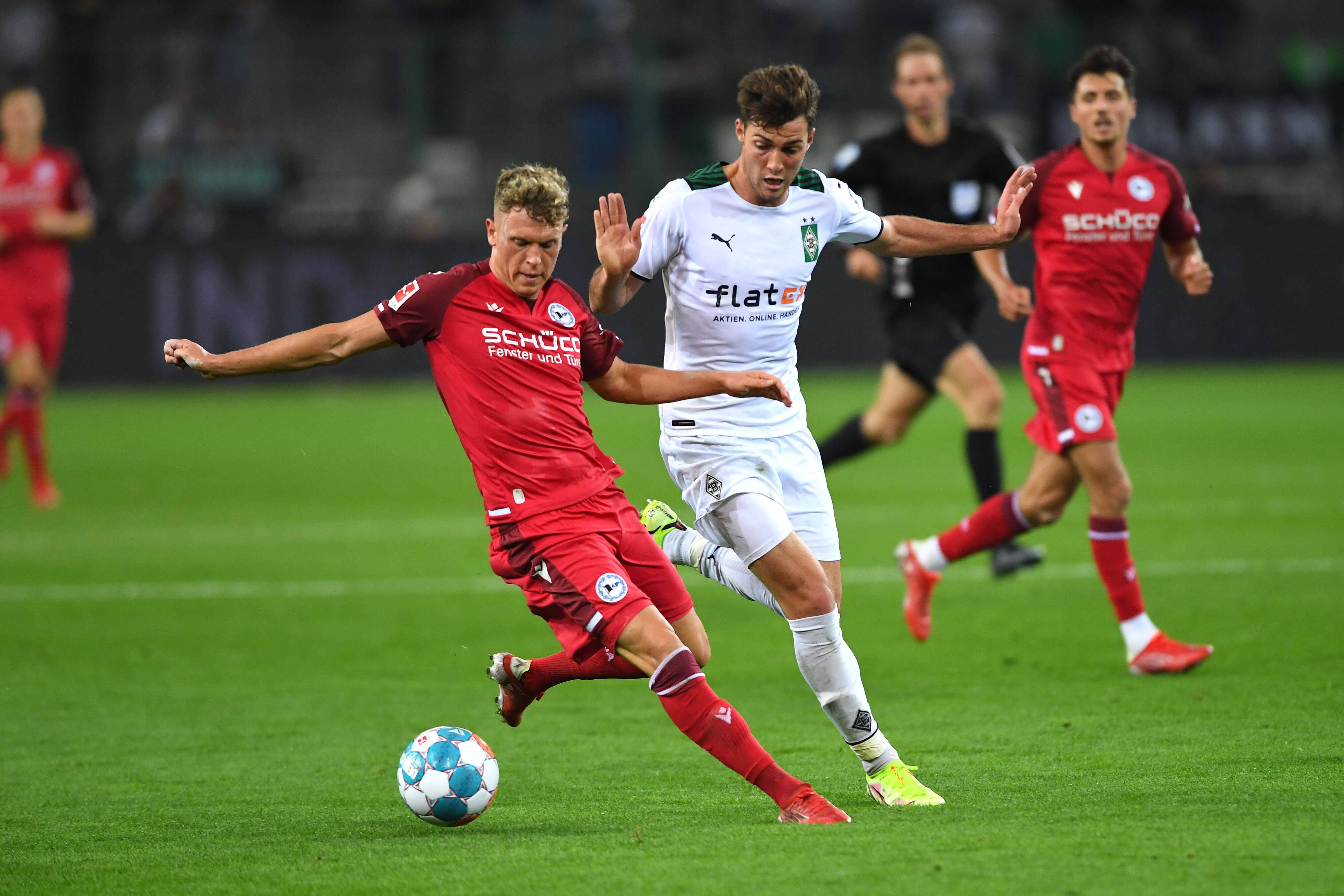 Gladbach-Profi Joe Scally (M.) im Zweikampf mit Bielefelds Robin Hack (l.) beim Bundesliga-Duell zwischen der Borussia und der Arminia am 12. September 2021