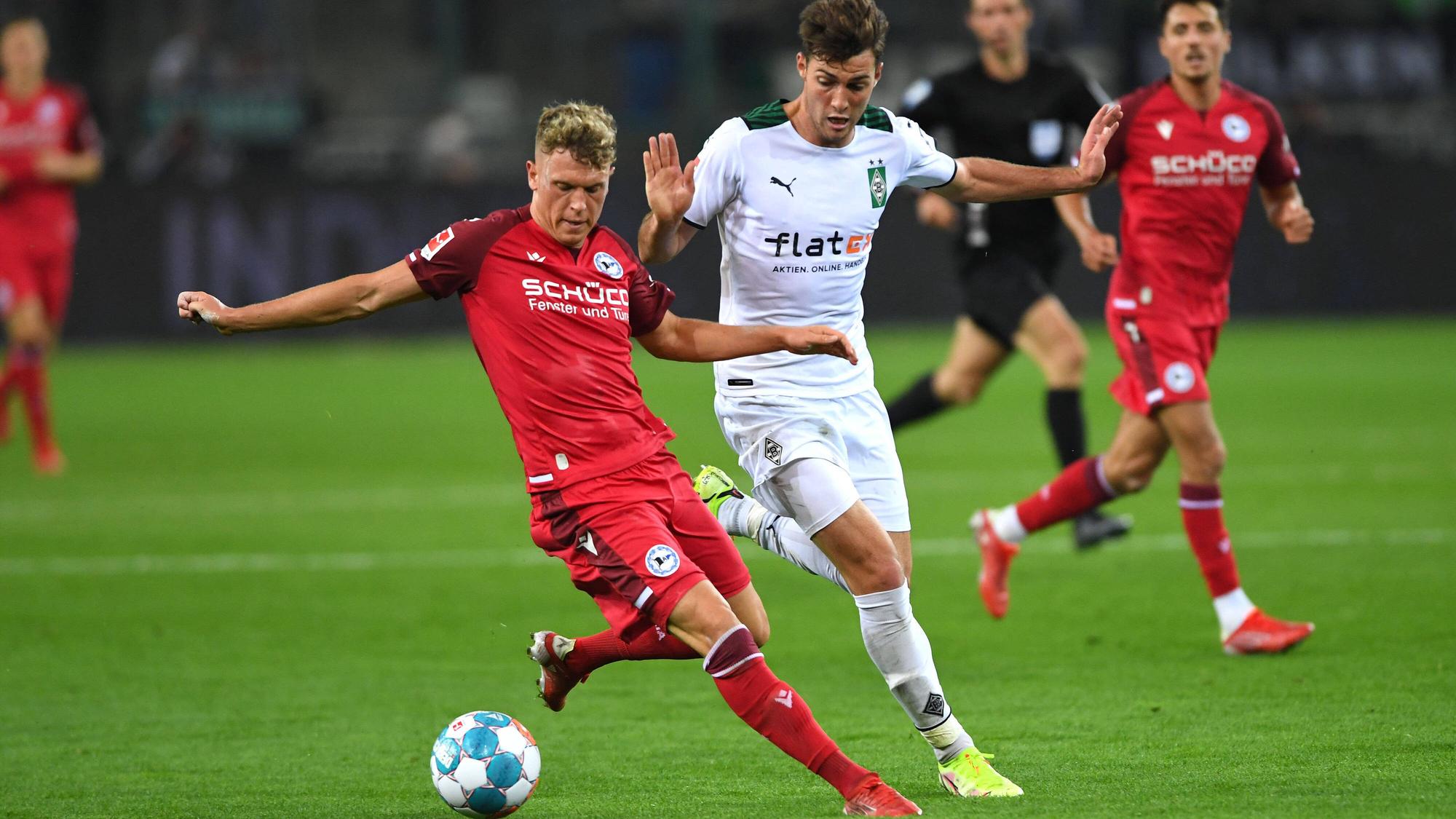 Gladbach-Profi Joe Scally (M.) im Zweikampf mit Bielefelds Robin Hack (l.) beim Bundesliga-Duell zwischen der Borussia und der Arminia am 12. September 2021