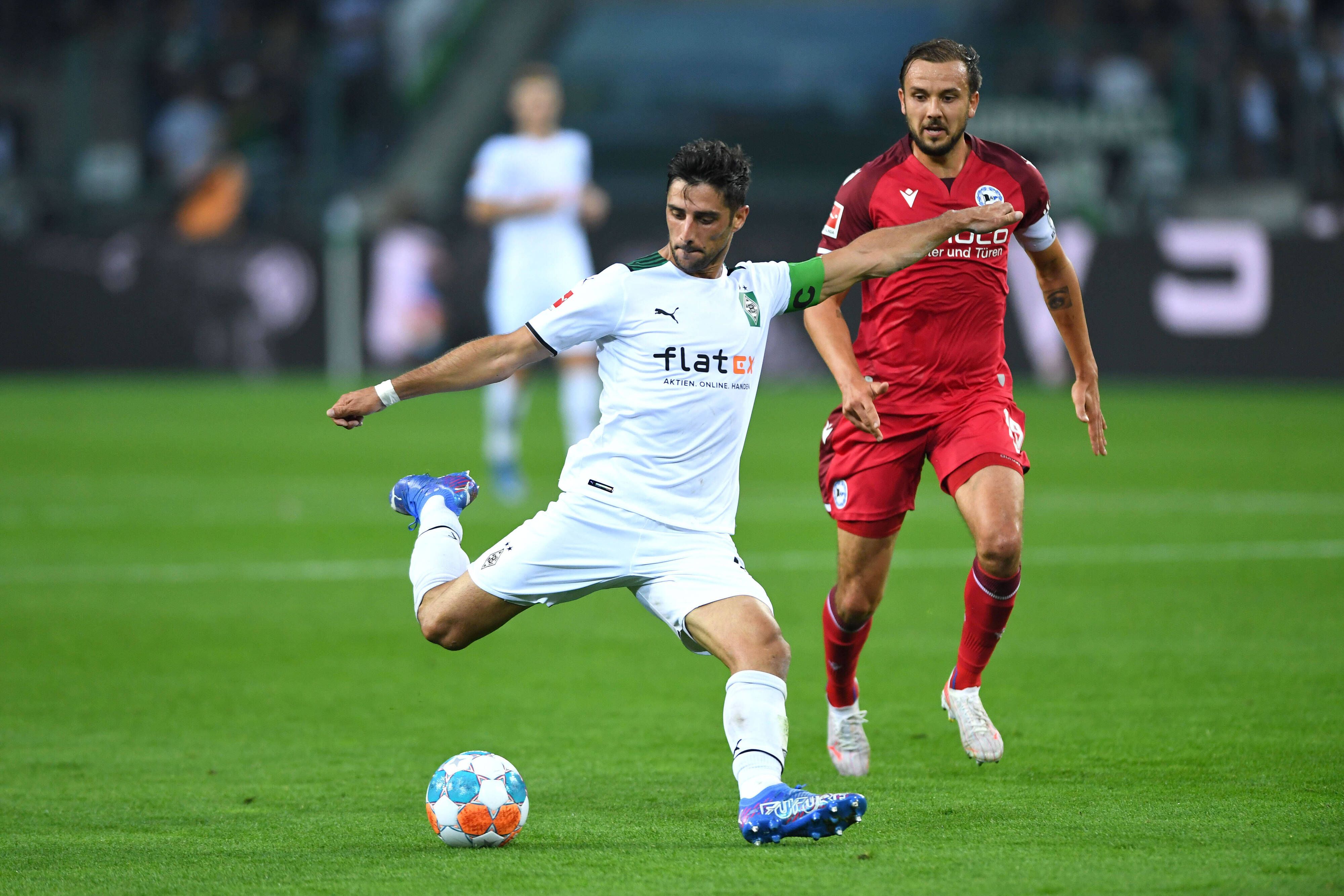 Gladbach-Kapitän Lars Stindl (l.) im Bundesliga-Duell der Borussia gegen Arminia Bielefeld am 12. September 2021. Rechts im Bild: Bielefelds Manuel Prietl. Stindl schießt in dieser Szene auf das Tor.
