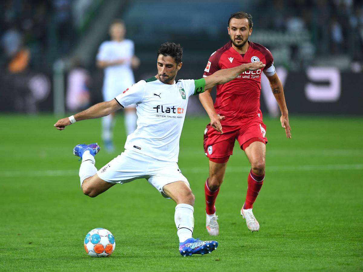 Gladbach-Kapitän Lars Stindl (l.) im Bundesliga-Duell der Borussia gegen Arminia Bielefeld am 12. September 2021. Rechts im Bild: Bielefelds Manuel Prietl. Stindl schießt in dieser Szene auf das Tor.