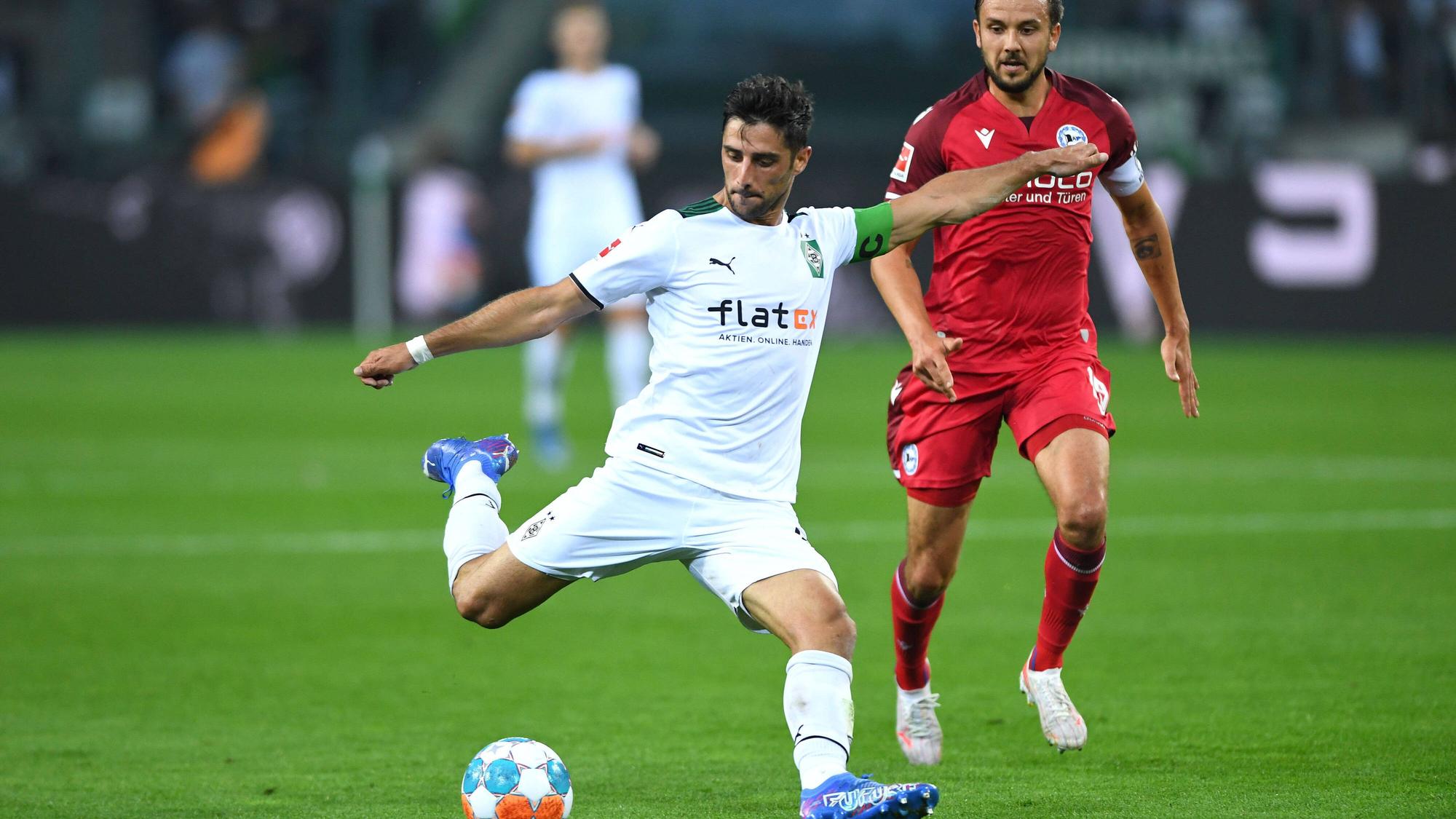 Gladbach-Kapitän Lars Stindl (l.) im Bundesliga-Duell der Borussia gegen Arminia Bielefeld am 12. September 2021. Rechts im Bild: Bielefelds Manuel Prietl. Stindl schießt in dieser Szene auf das Tor.