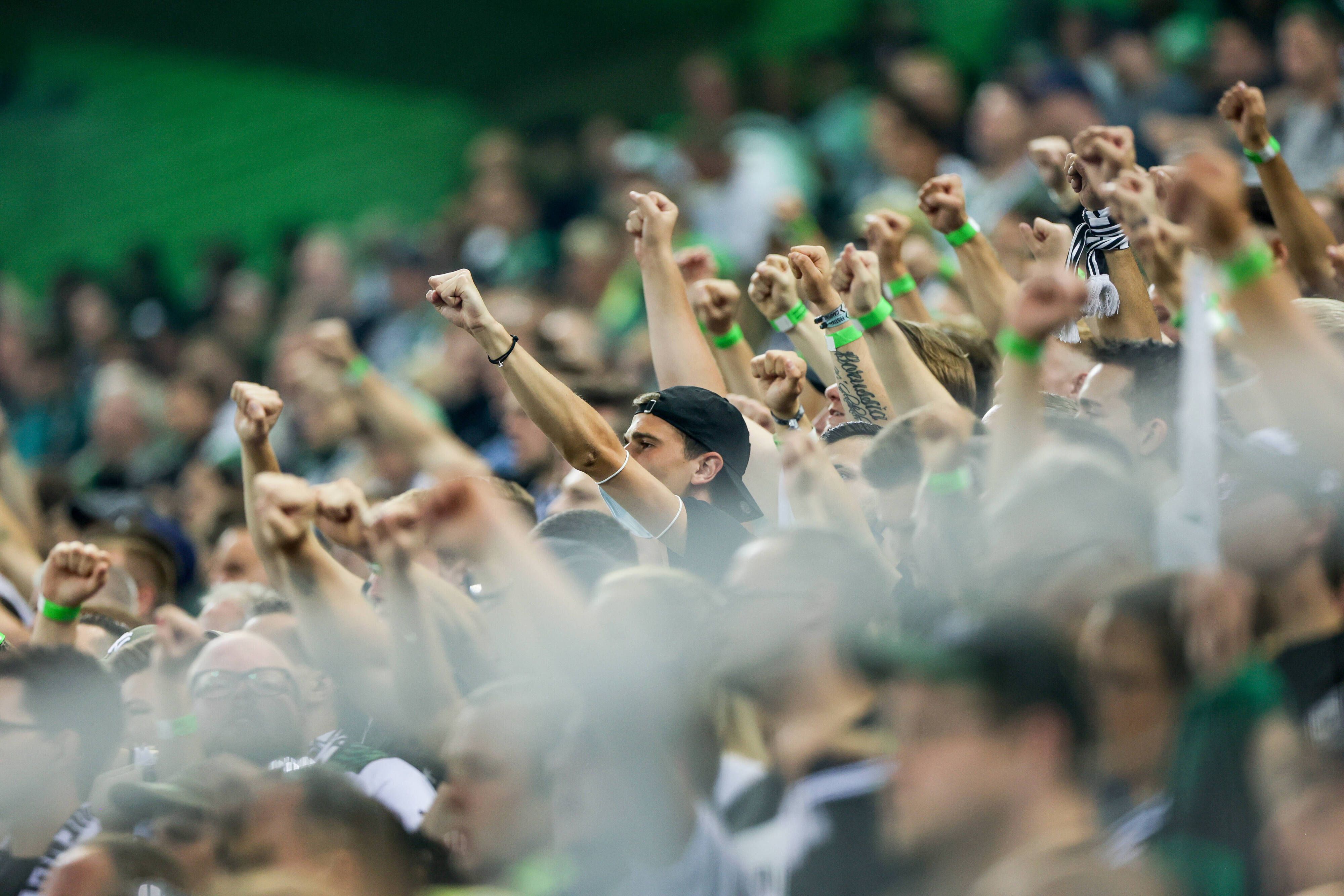 Fans von Borussia Mönchengladbach beim Bundesliga-Duell am 12. September 2021 gegen Arminia Bielefeld im Borussia-Park. Zahlreiche Fans strecken ihre Arme nach oben.