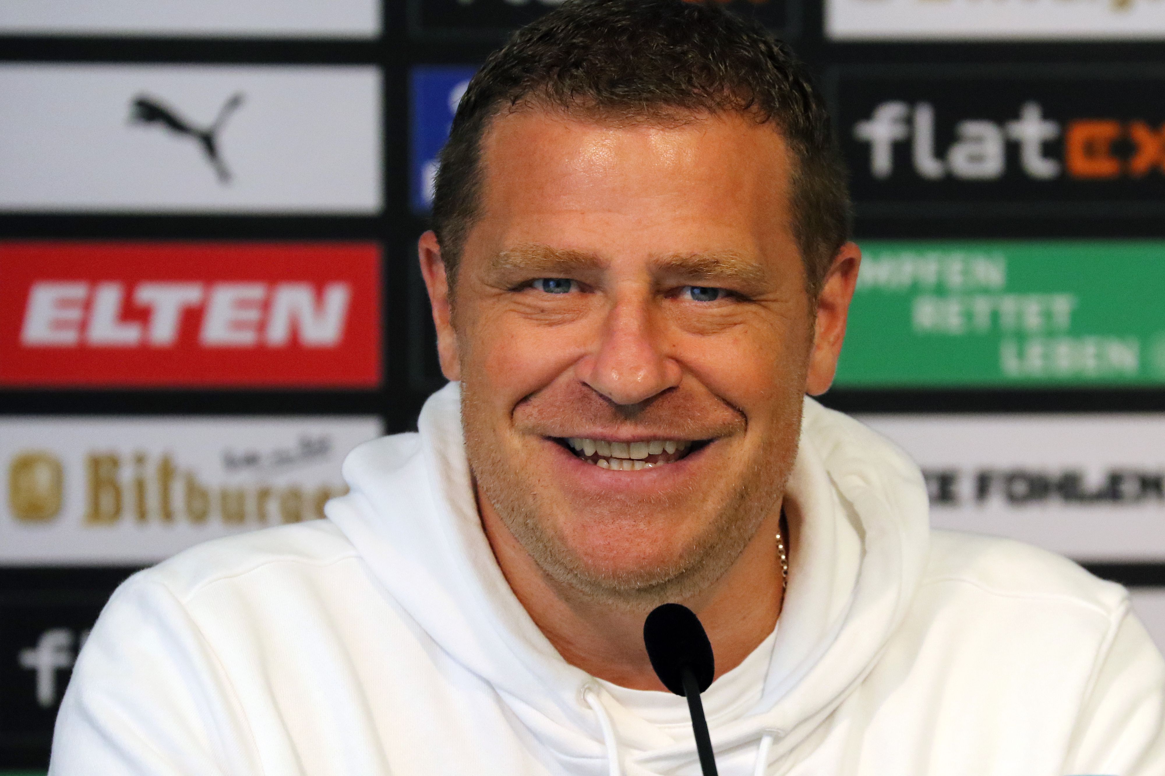 Max Eberl, Manager von Borussia Mönchengladbach. Auf diesem Foto ist der 47-Jährige bei einer Pressekonferenz am 10. September 2021 im Borussia-Park zu sehen. Eberl lächelt in die Kamera.