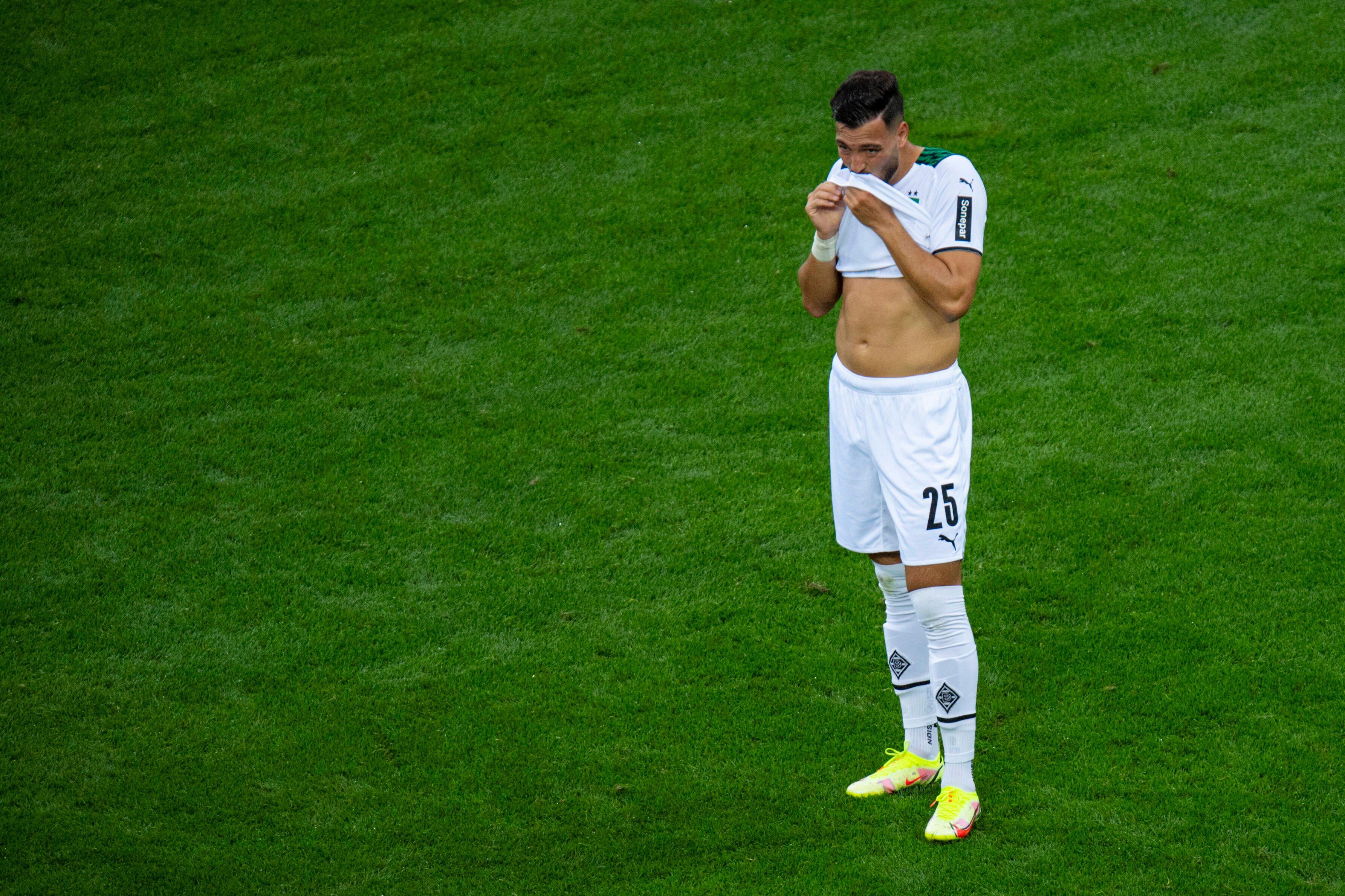 Ramy Bensebaini von Borussia Mönchengladbach wischt sich beim Bundesliga-Spiel gegen bei Bayer Leverkusen am 21. August 2021 den Mund am Trikot ab.