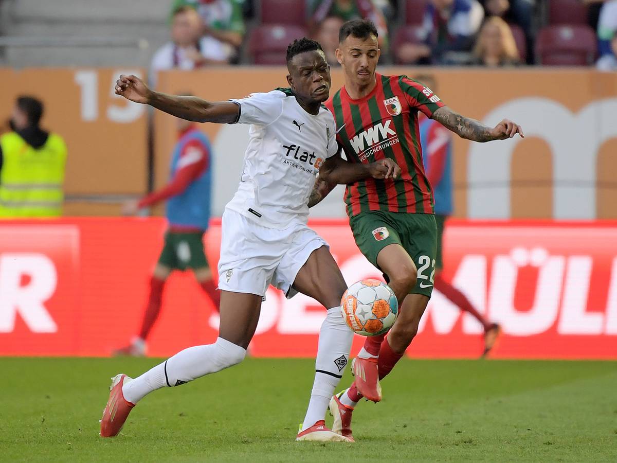 Gladbach-Profi Denis Zakaria (l.) im Duell mit Amaral Borduchi Iago (r.) vom FC Augsburg beim Bundesliga-Duell am 18. September 2021 in der Augsburger Arena. Beide kämpfen um den Ball.
