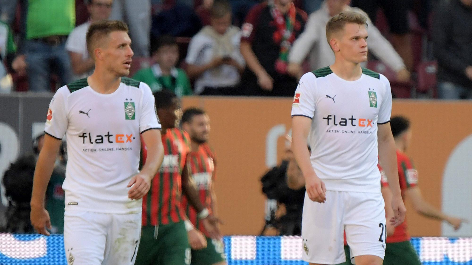 Patrick Herrmann (l.) und Matthias Ginter (r.), Spieler von Borussia Mönchengladbach, gehen mit enttäuschtem Blick vom Platz.