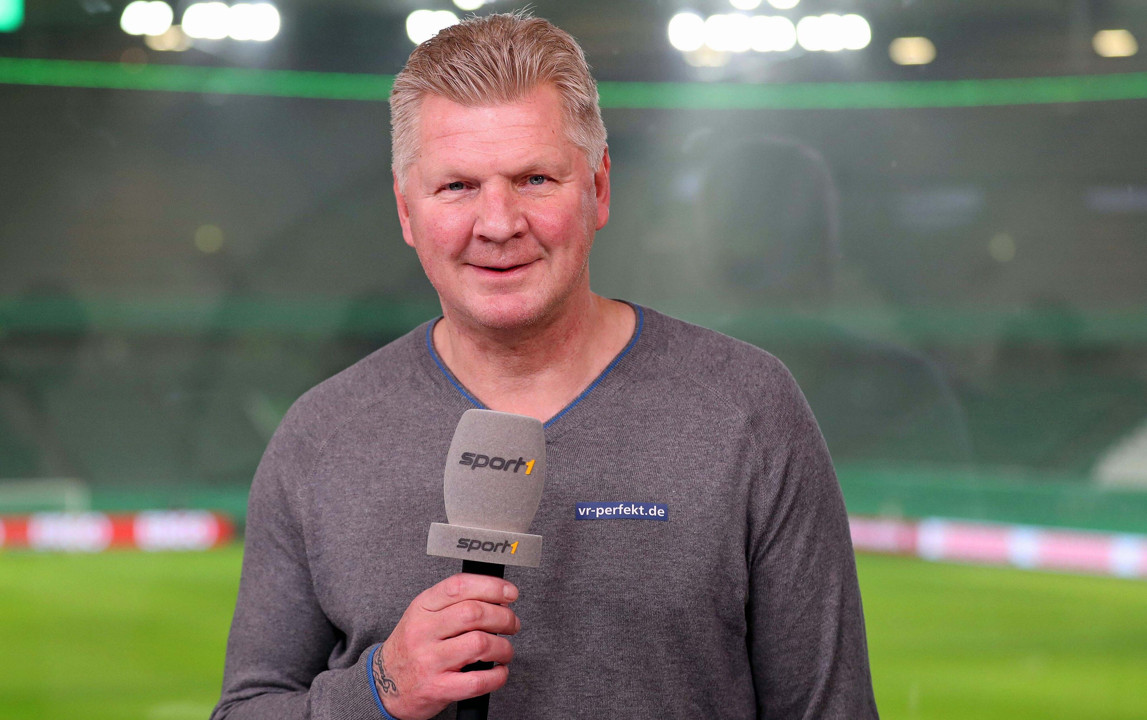 Ex-Gladbach-Spieler Stefan Effenberg arbeitet als TV-Experte für den Sender „Sport1“. Auf diesem Foto ist der ehemalige Nationalspieler am 3. Februar 2021 zu sehen. Effenberg hält das Mikro in der Hand und lächelt in die Kamera.