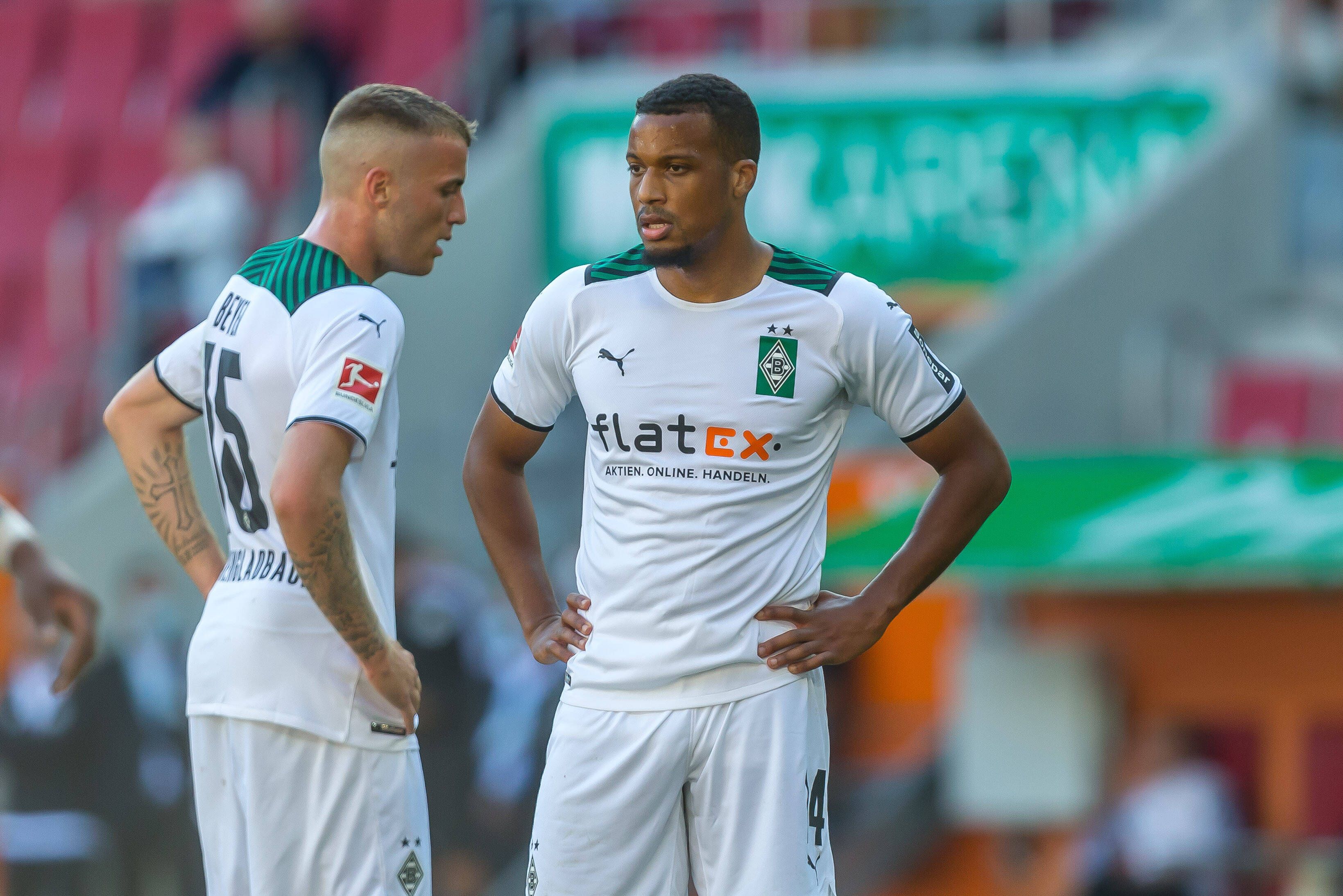 Alassane Plea (l.) und Jordan Beyer (r.) von Borussia Mönchengladbach stehen am 18. September 2021 mit den Händen in den Hüften auf den Fußballplatz und schauen enttäuscht.