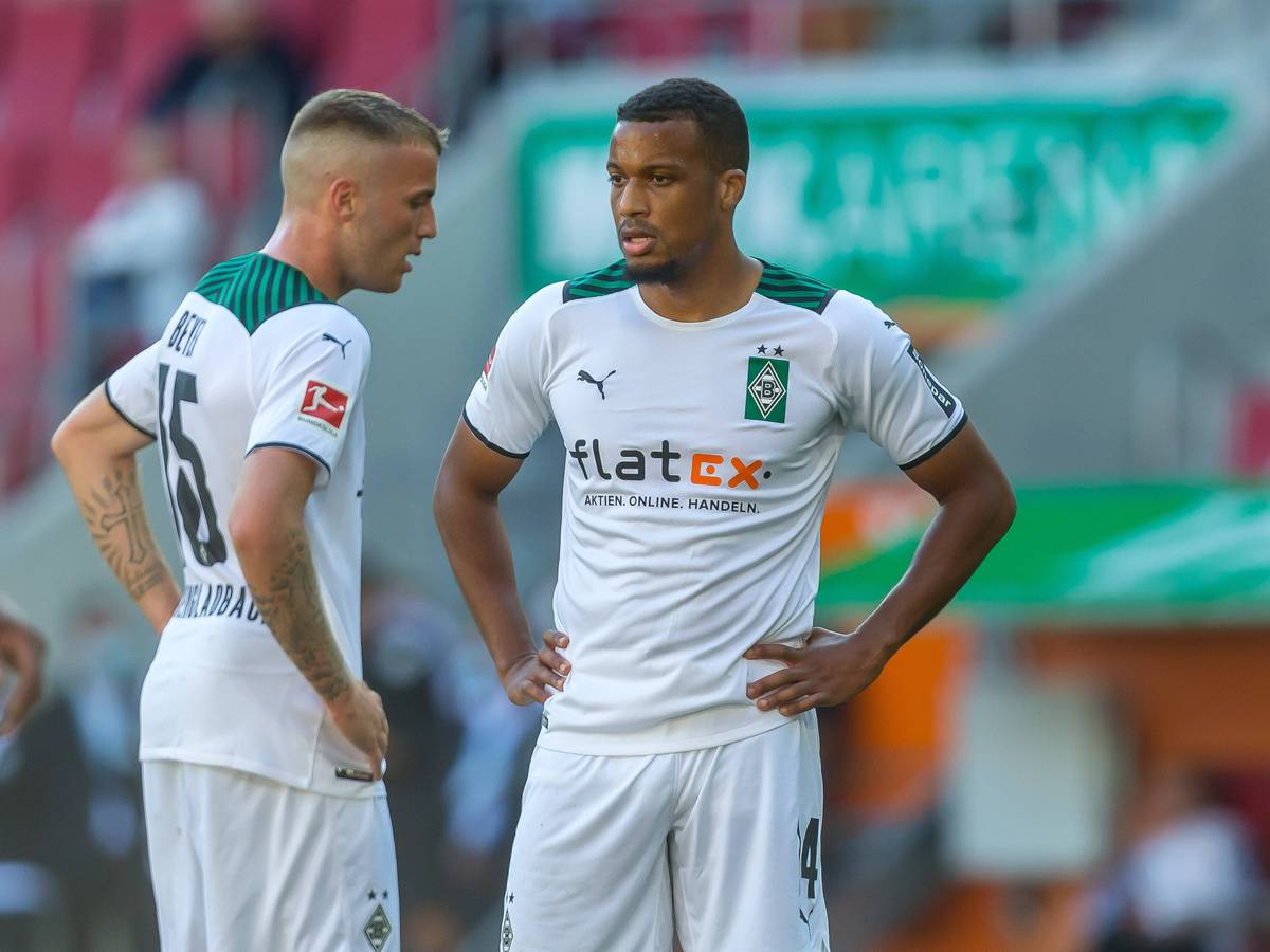 Alassane Plea (l.) und Jordan Beyer (r.) von Borussia Mönchengladbach stehen am 18. September 2021 mit den Händen in den Hüften auf den Fußballplatz und schauen enttäuscht.