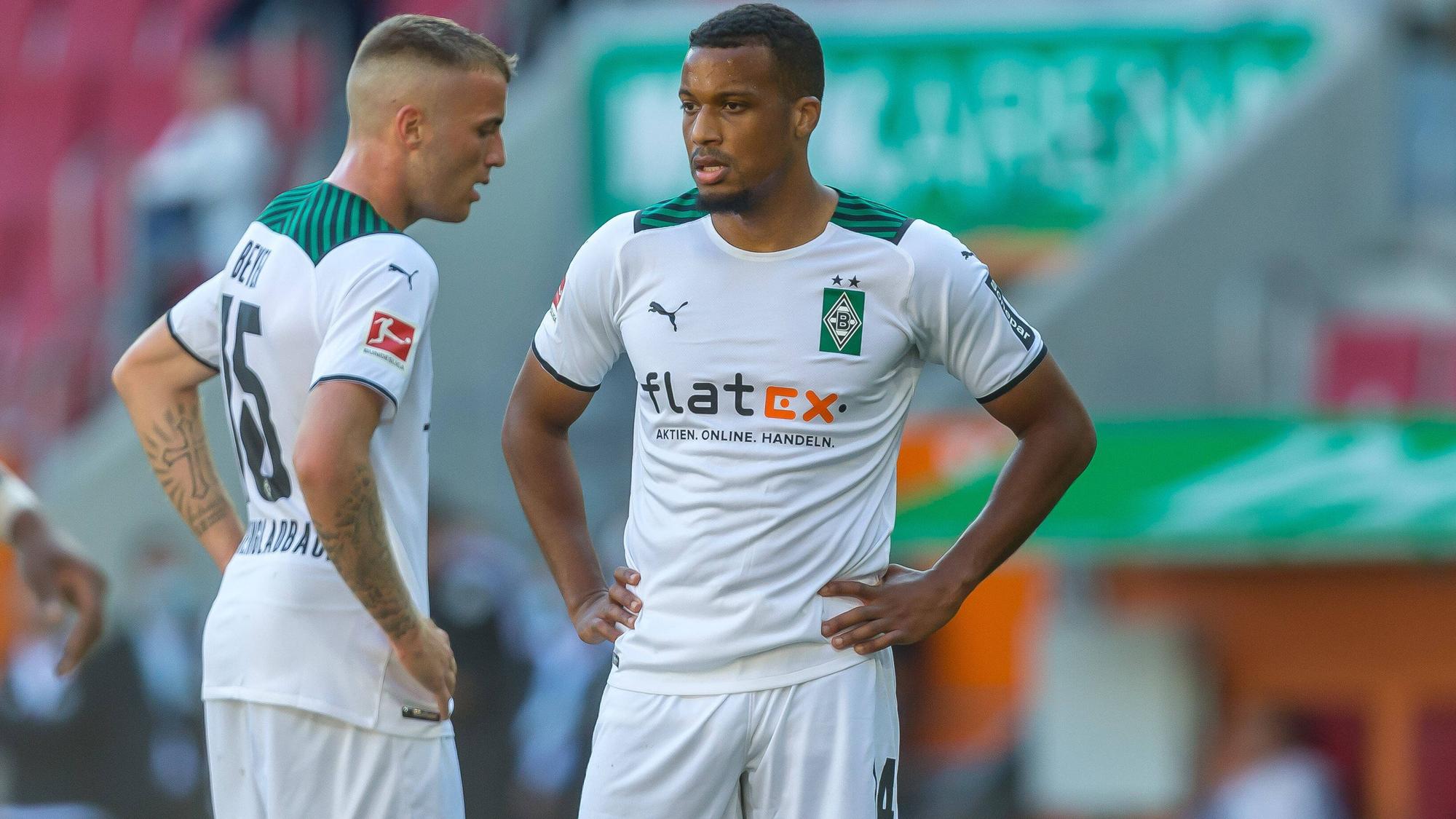 Alassane Plea (l.) und Jordan Beyer (r.) von Borussia Mönchengladbach stehen am 18. September 2021 mit den Händen in den Hüften auf den Fußballplatz und schauen enttäuscht.