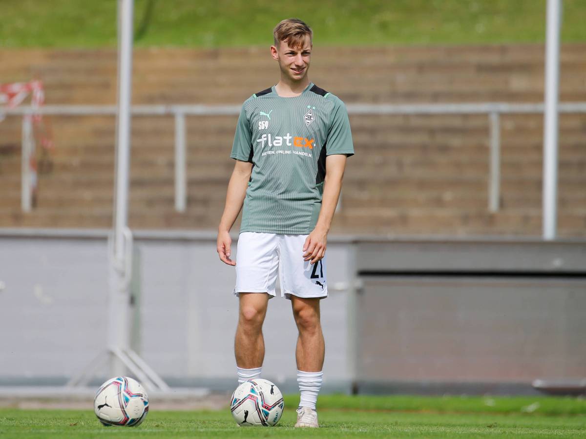 Luiz Skraback von Borussia Mönchengladbach, hier am 21. August 2021, steht lachend mit dem Ball am Fuß auf dem Fußballplatz.