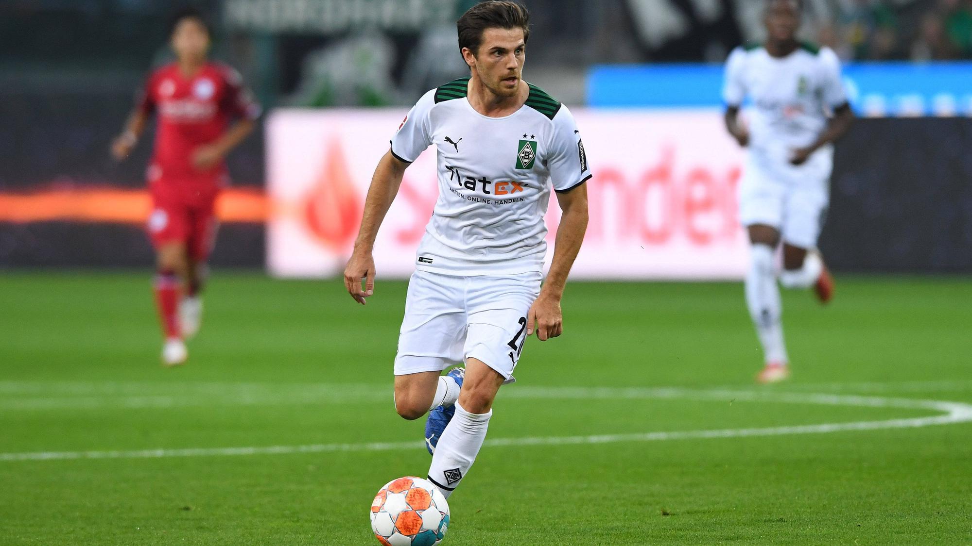 DFB-Nationalspieler Jonas Hofmann, hier zu sehen am 12. September 2021 beim Bundesliga-Duell seines Vereines Borussia Mönchengladbach gegen Arminia Bielefeld. Hofmann führt den Ball am linken Fuß und schaut auf das Spielgeschehen vor sich.