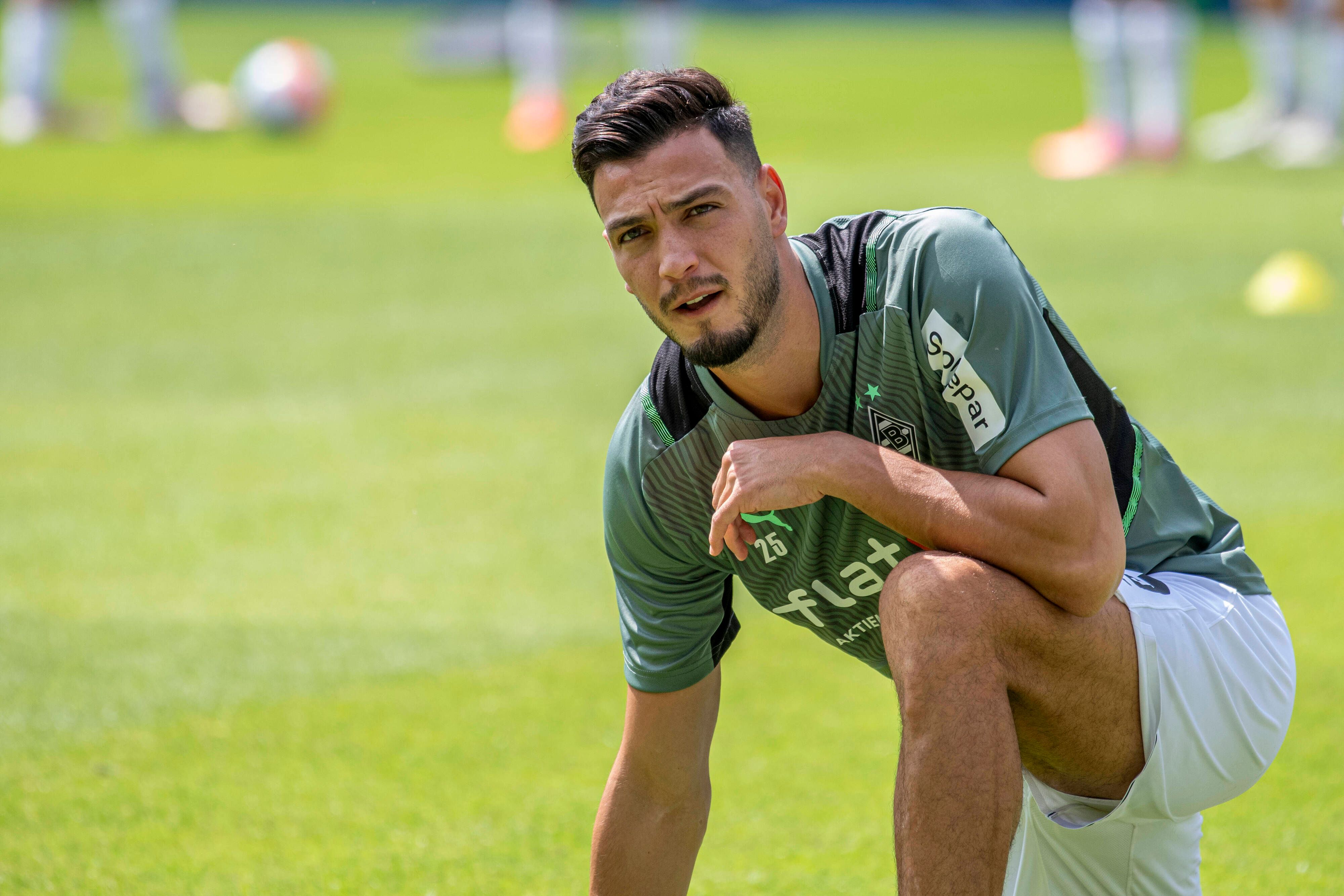 Ramy Bensebaini von Borussia Mönchengladbachschaut am 17. Juli bei der Vorbereitung auf den Boden kniend nach oben.