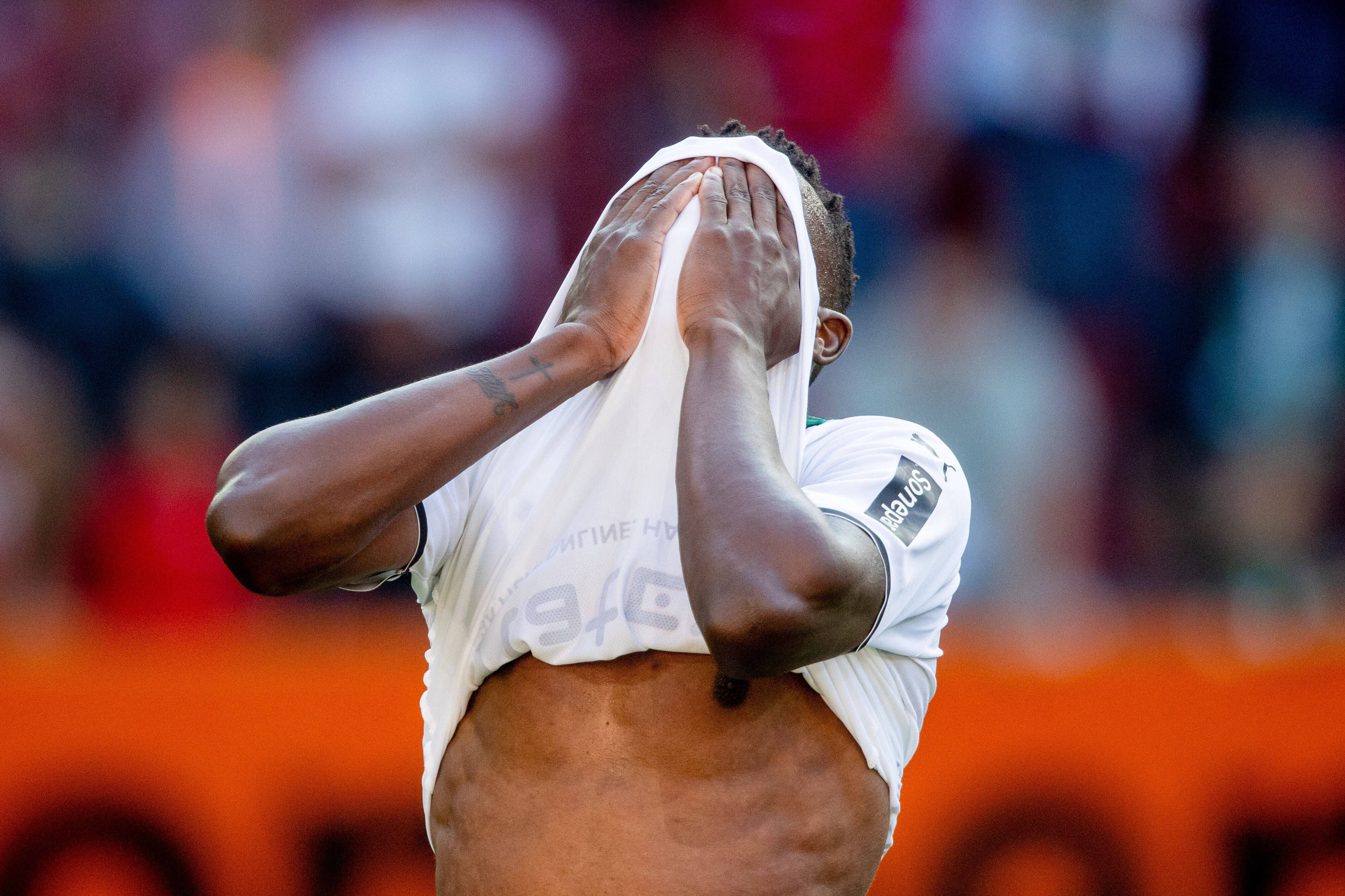 Denis Zakaria von Borussia Mönchengladbach hält sich nach der Niederlage beim FC Augsburg am 18. September 2021 enttäuscht die Hände vor sein Gesicht.