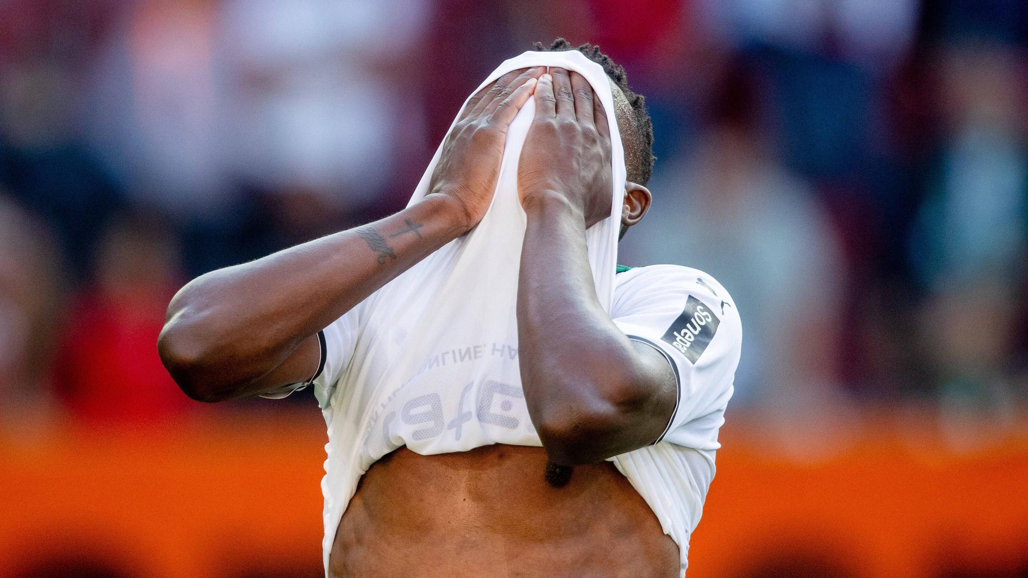 Denis Zakaria von Borussia Mönchengladbach hält sich nach der Niederlage beim FC Augsburg am 18. September 2021 enttäuscht die Hände vor sein Gesicht.
