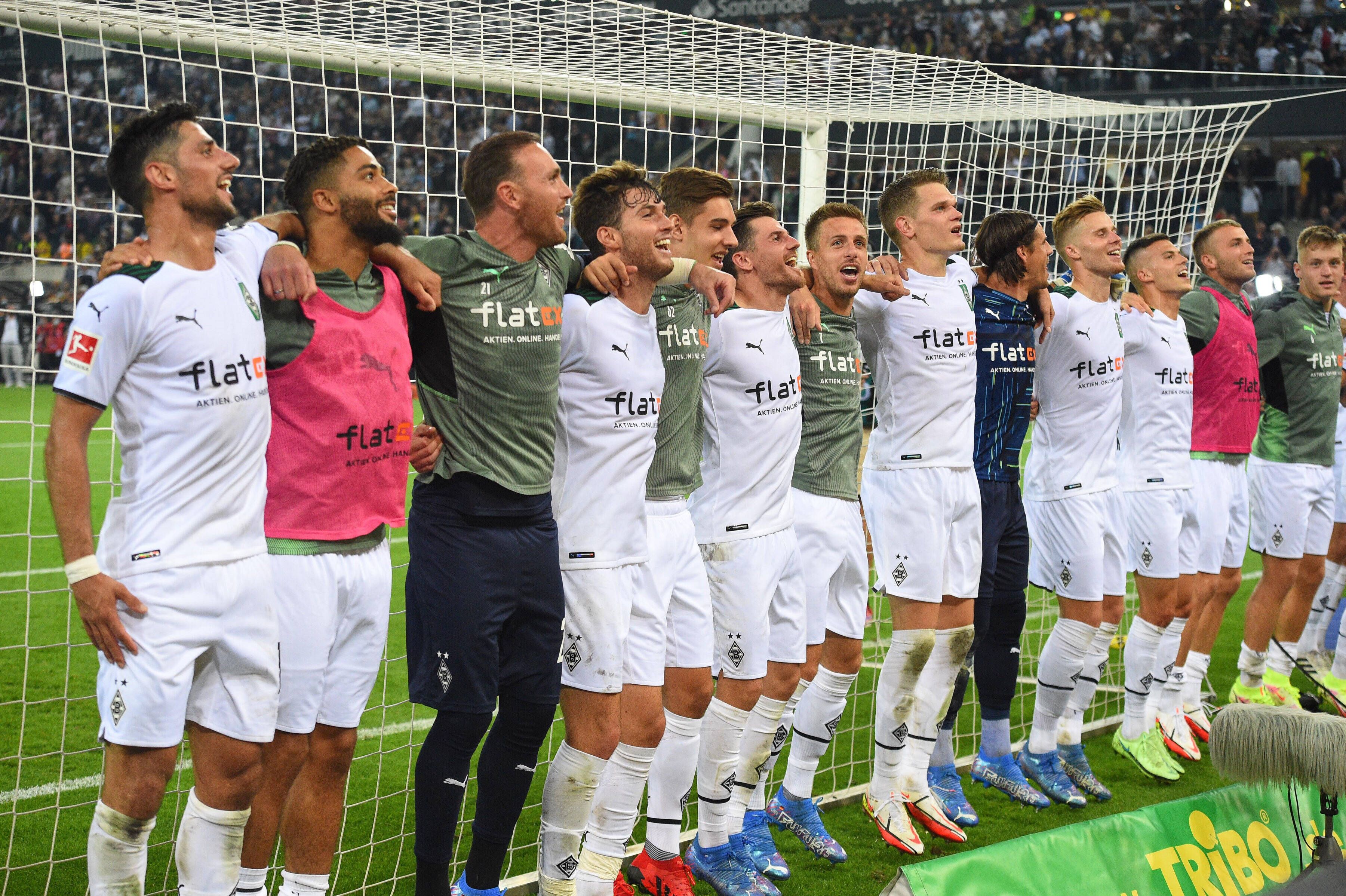Die Mannschaft von Borussia Mönchengladbach feiert Arm in Arm lachend den Sieg gegen den BVB am 25. September 2021.