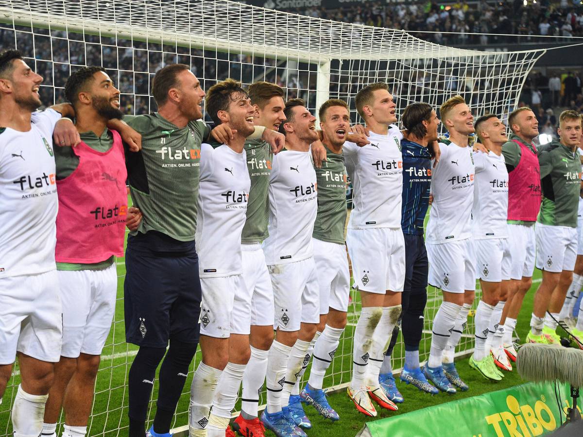Die Mannschaft von Borussia Mönchengladbach feiert Arm in Arm lachend den Sieg gegen den BVB am 25. September 2021.