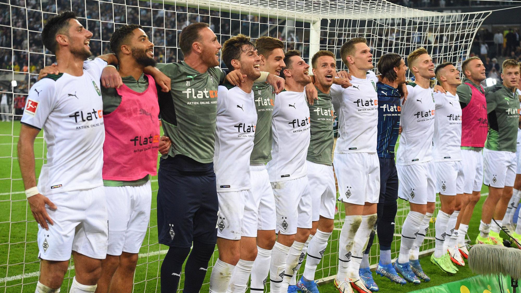 Die Mannschaft von Borussia Mönchengladbach feiert Arm in Arm lachend den Sieg gegen den BVB am 25. September 2021.