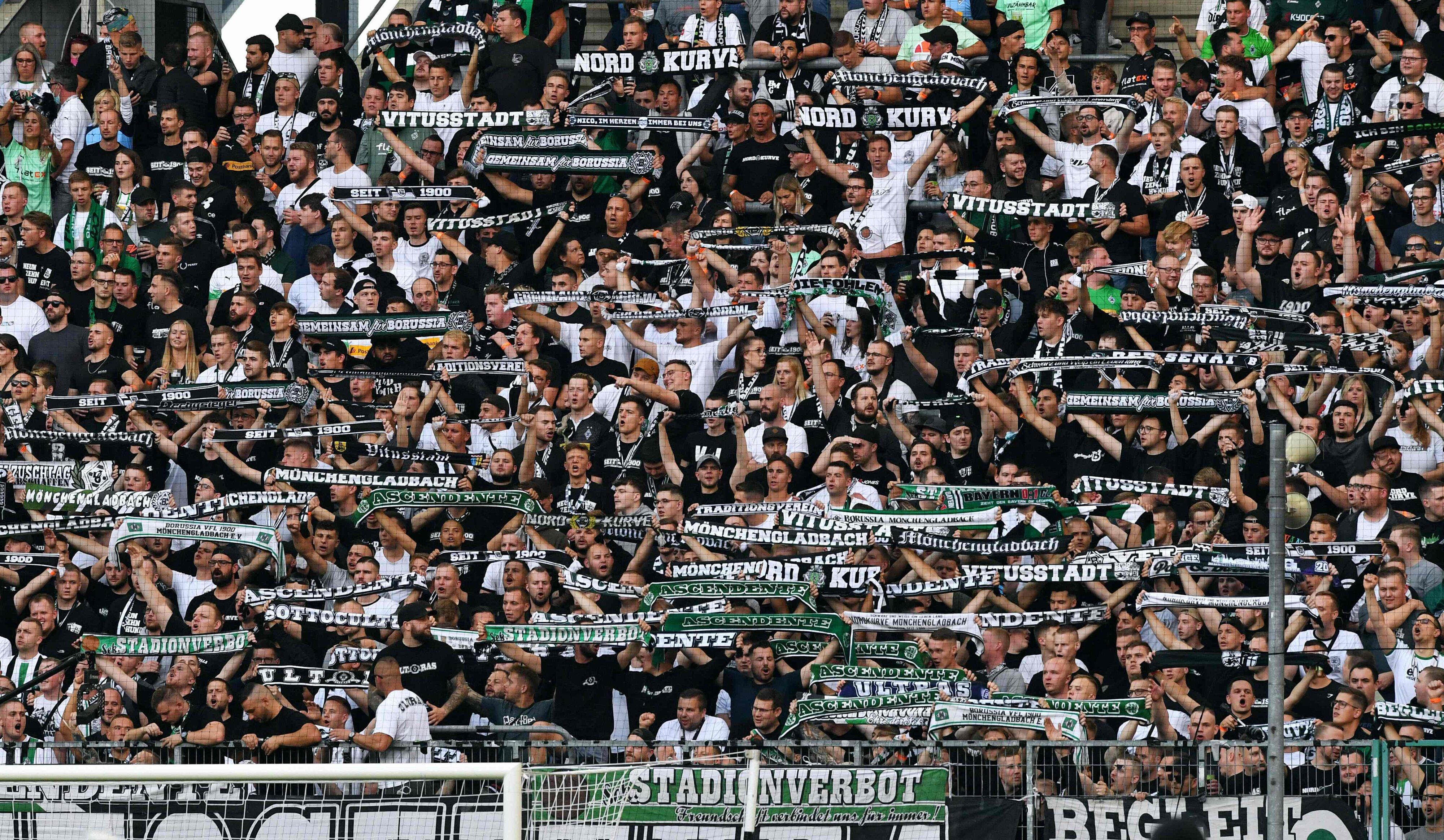 Moenchengladbach's fans display their scarves prior to the German first division Bundesliga football match Borussia Moenchengladbach v BVB Borussia Dortmund in Moenchengladbach, western Germany, on September 25, 2021. (Photo by UWE KRAFT / AFP) / DFL REGULATIONS PROHIBIT ANY USE OF PHOTOGRAPHS AS IMAGE SEQUENCES AND/OR QUASI-VIDEO