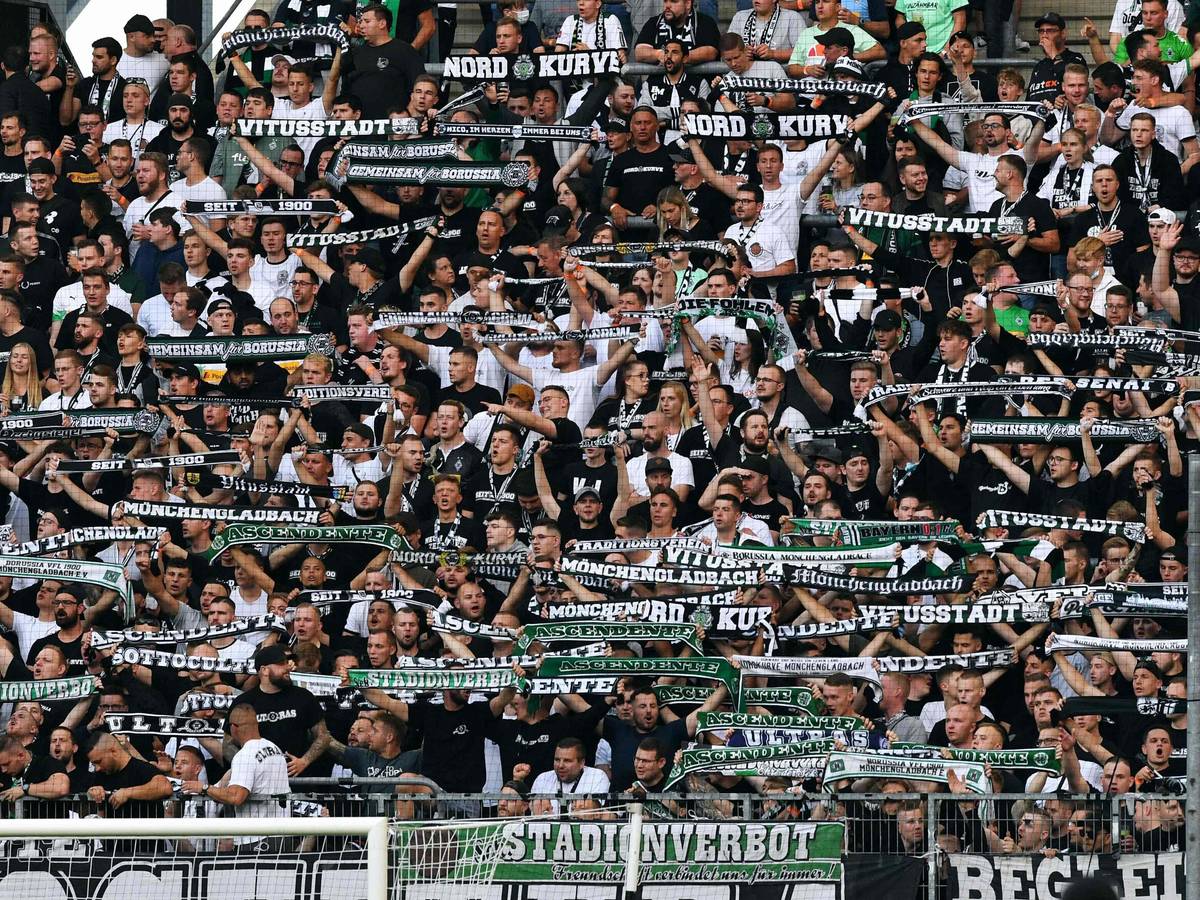 Moenchengladbach's fans display their scarves prior to the German first division Bundesliga football match Borussia Moenchengladbach v BVB Borussia Dortmund in Moenchengladbach, western Germany, on September 25, 2021. (Photo by UWE KRAFT / AFP) / DFL REGULATIONS PROHIBIT ANY USE OF PHOTOGRAPHS AS IMAGE SEQUENCES AND/OR QUASI-VIDEO