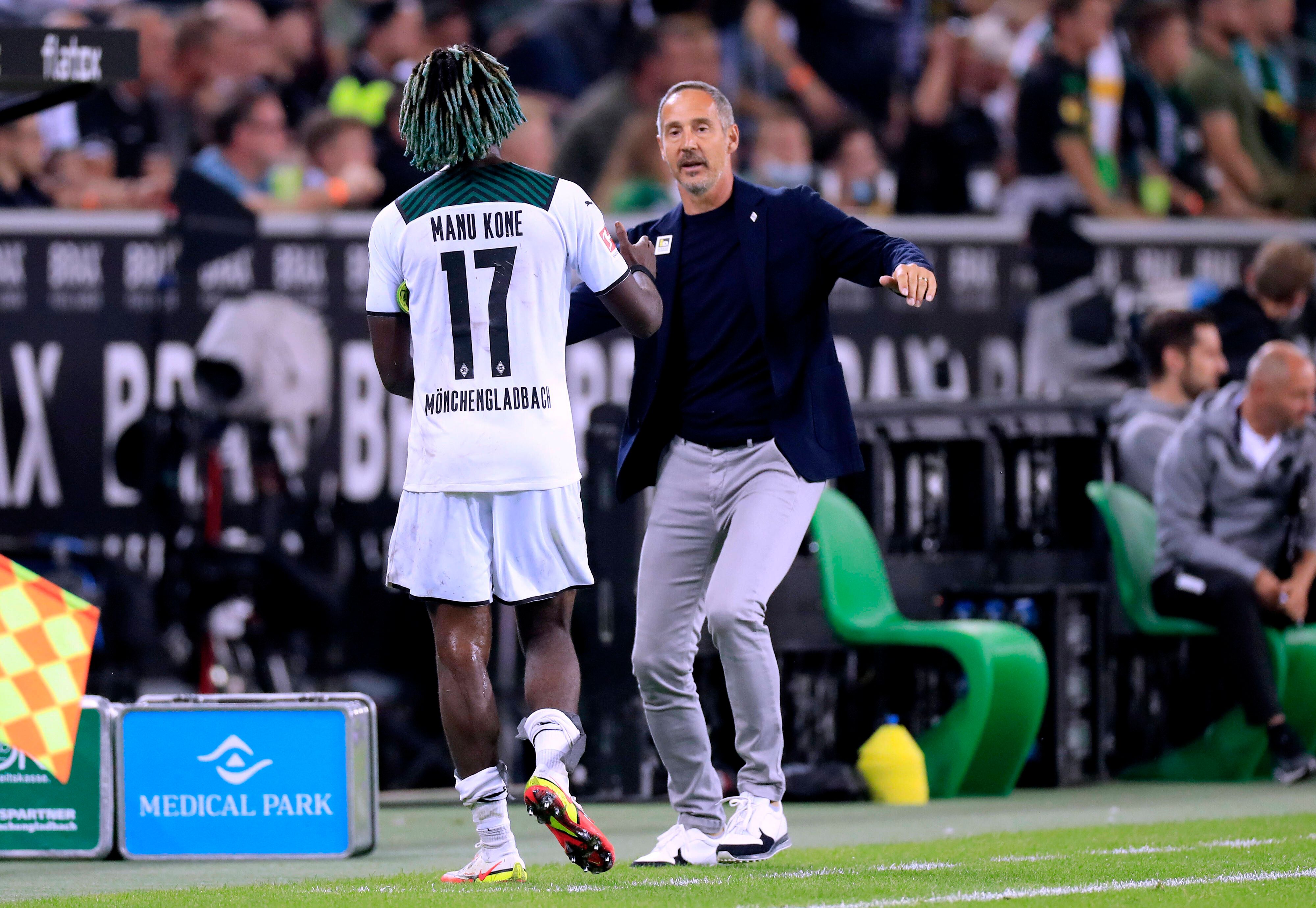 Gladbach-Trainer Adi Hütter (r.) klatscht seinen Mittelfeldspieler Manu Koné (l.) bei dessen Auswechslung während des Bundesliga-Duells mit Dortmund am 25. September 2021 im Borussia-Park ab.
