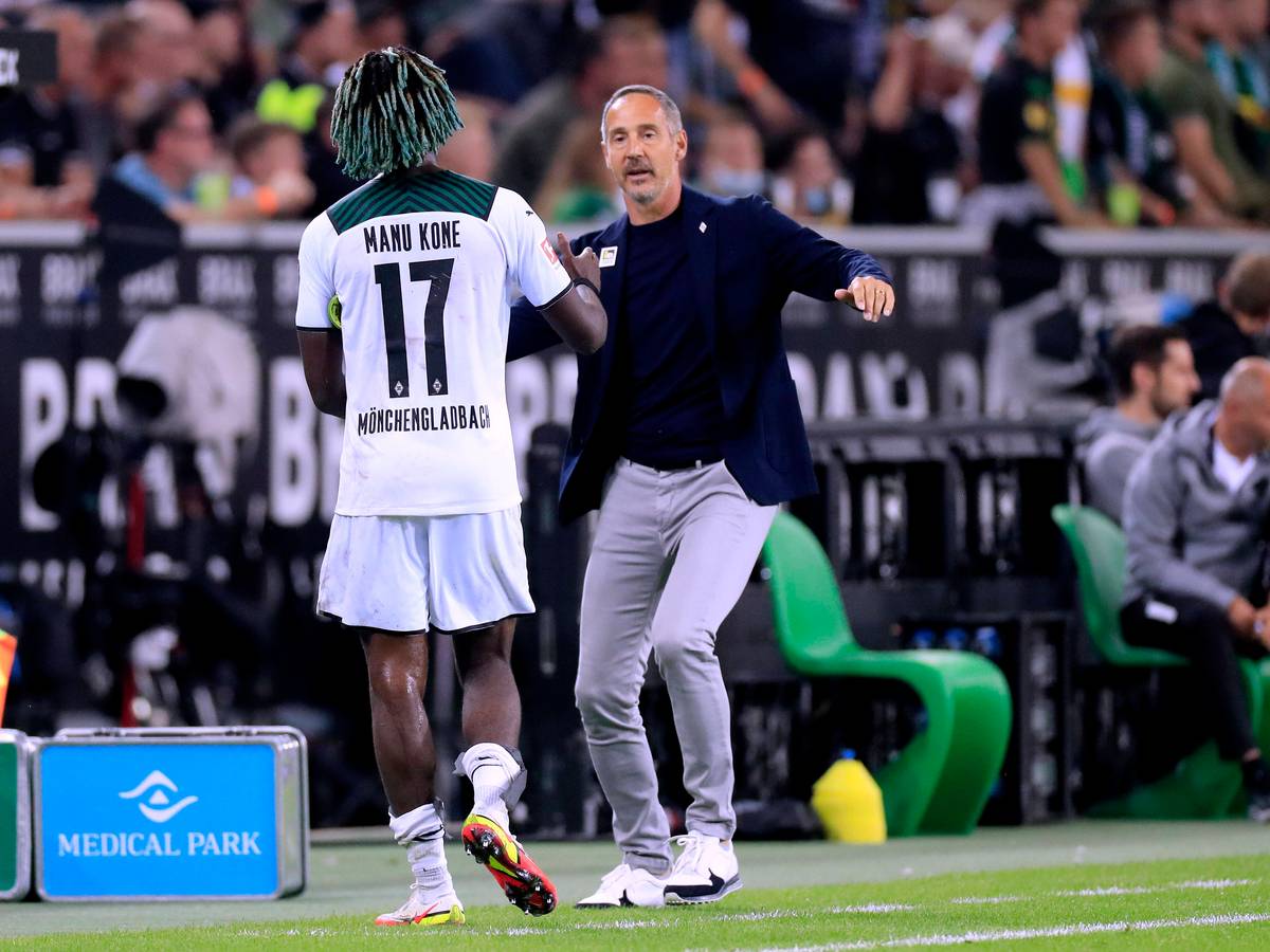 Gladbach-Trainer Adi Hütter (r.) klatscht seinen Mittelfeldspieler Manu Koné (l.) bei dessen Auswechslung während des Bundesliga-Duells mit Dortmund am 25. September 2021 im Borussia-Park ab.